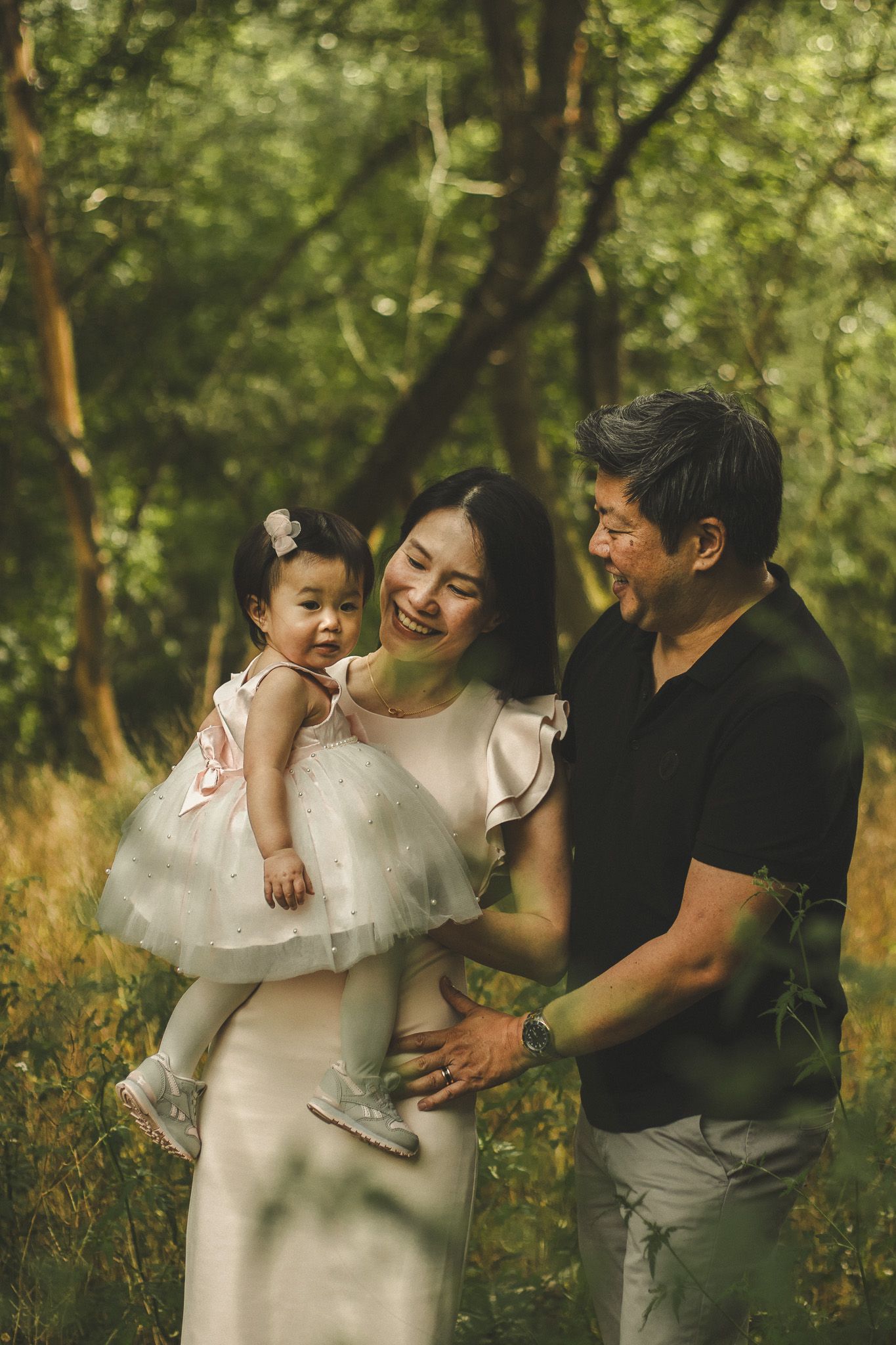 Family photography in Toronto of parents and their daughter, natural landscape of forest
