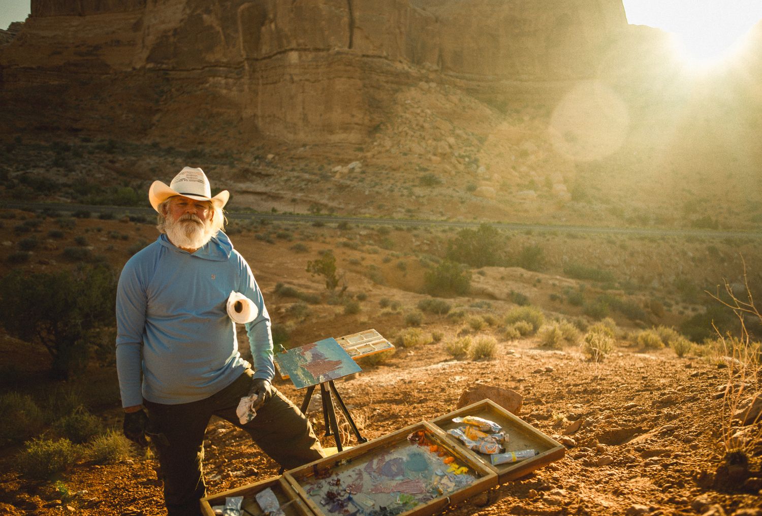 Portrait of a painter in Utah during sunset, painting the scenery