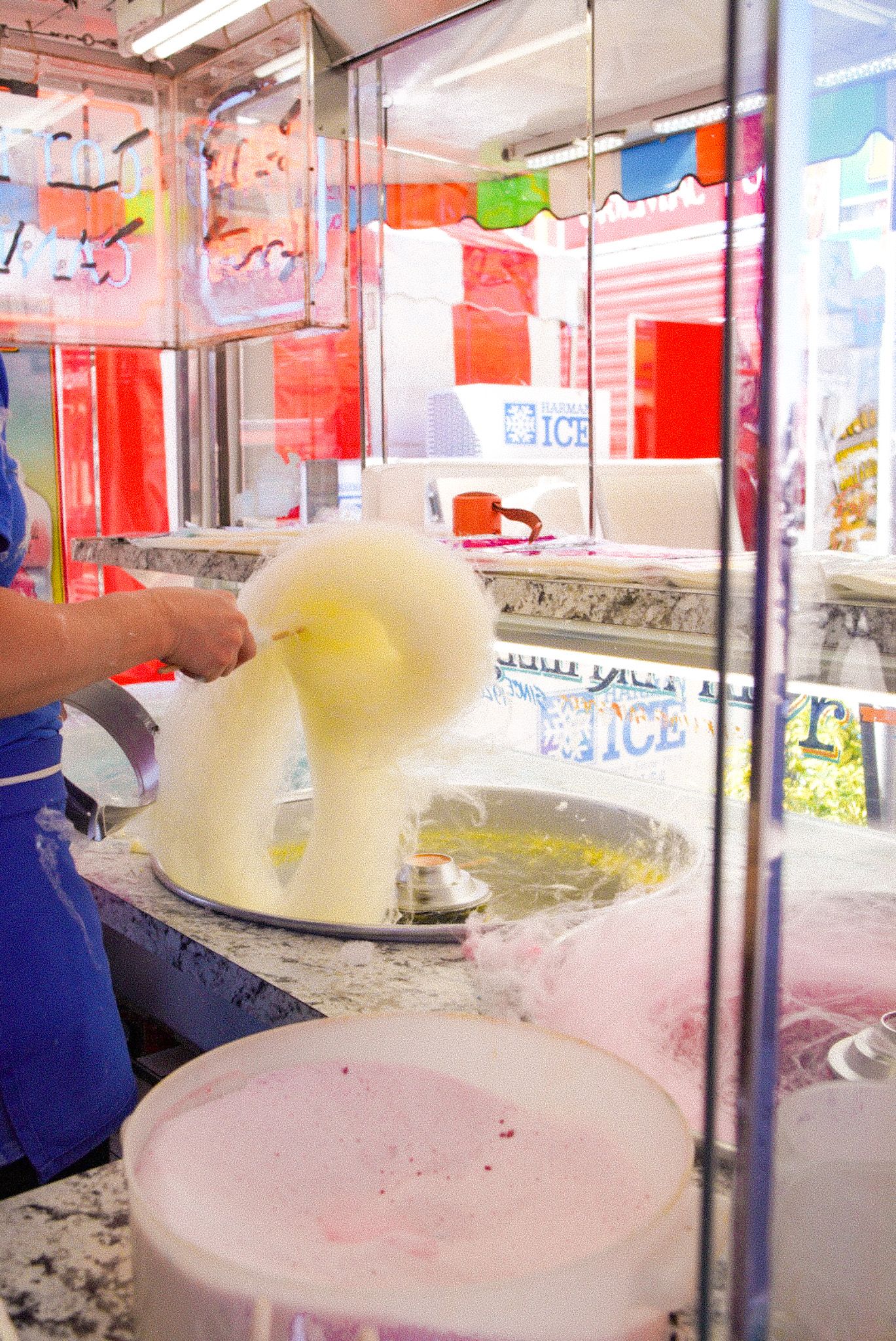 Ice cream being scooped and served in a retail display counter.
