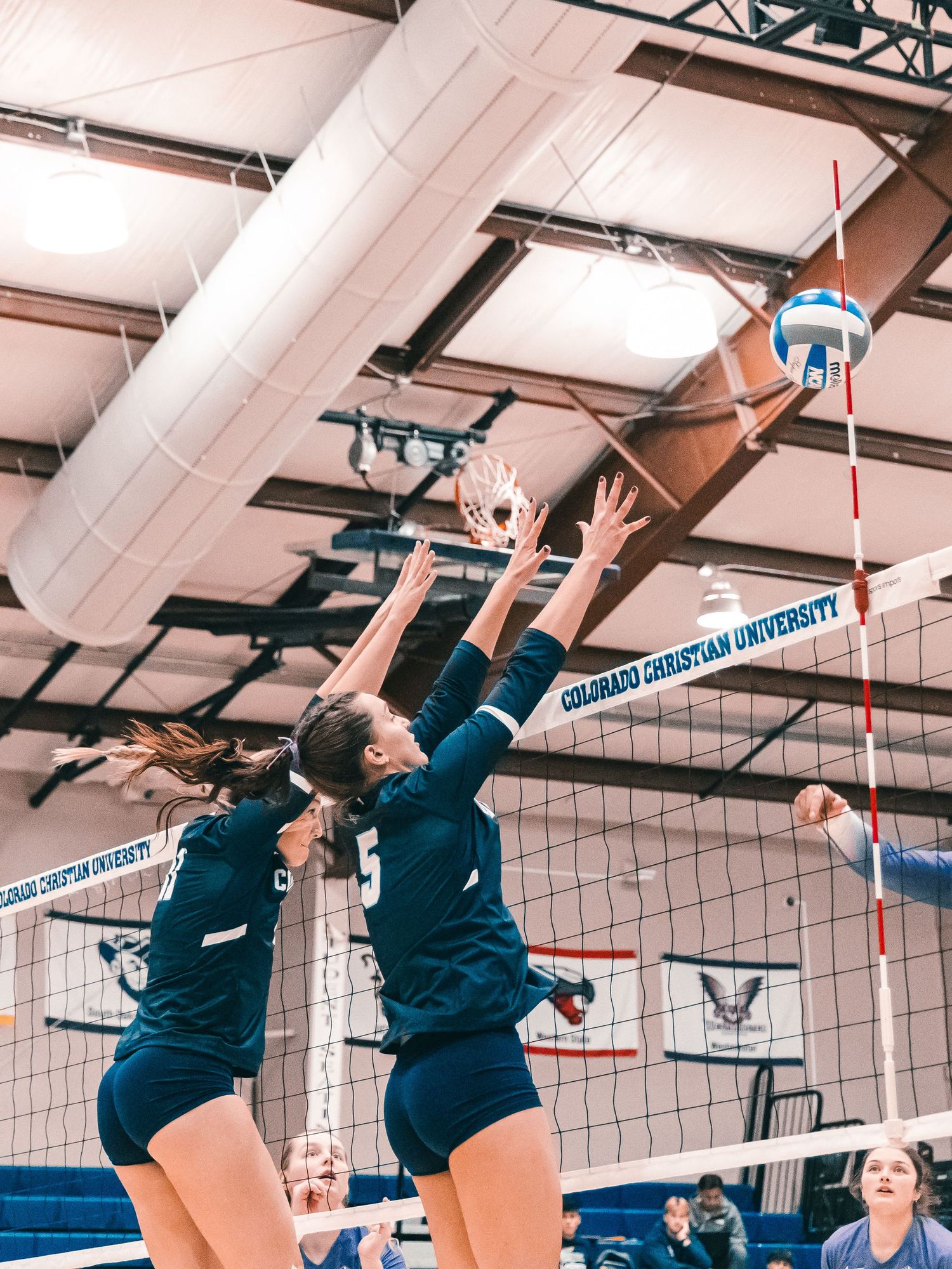 Colorado Christian University women's volleyball players #1 and teammate blocking at the net