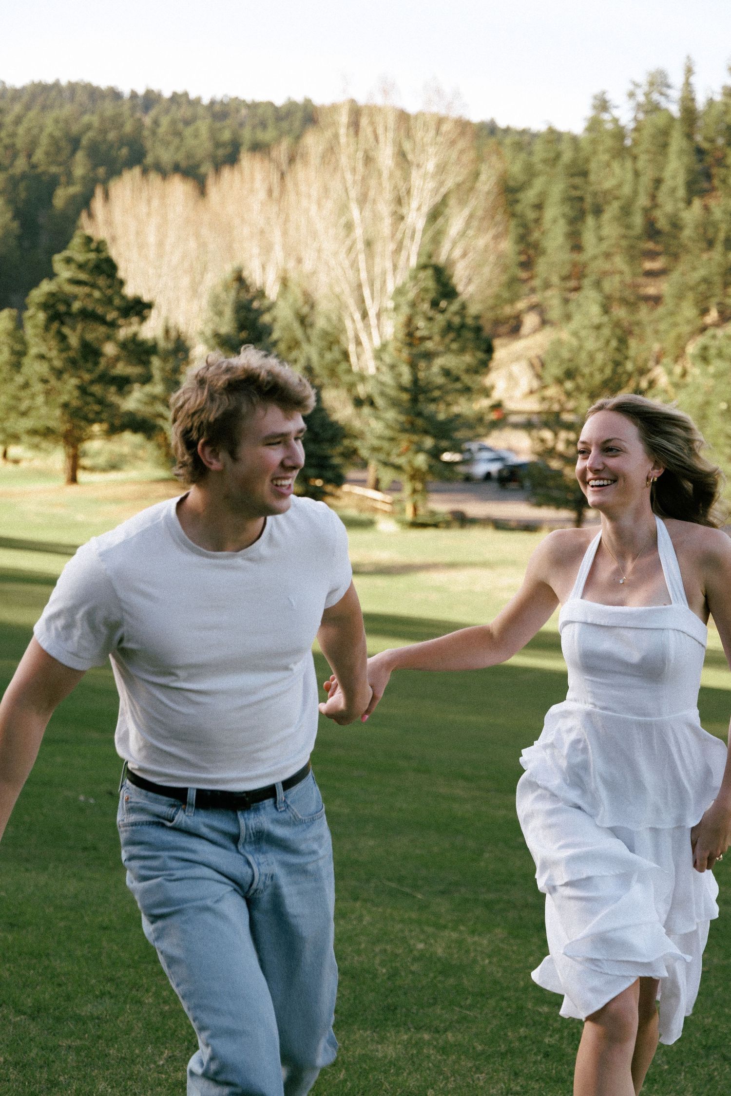 Evergreen Colorado engagement photoshoot, running and laughing through a meadow