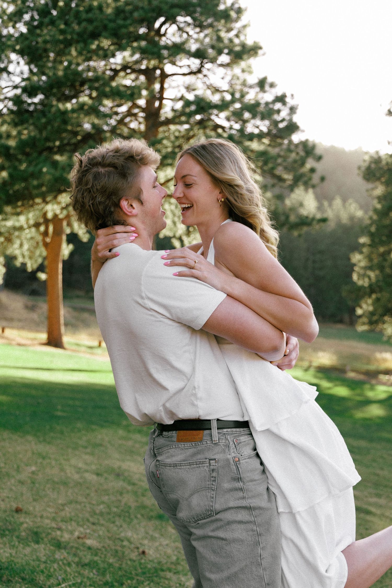 Evergreen Colorado engagement, the laughing  couple embrace