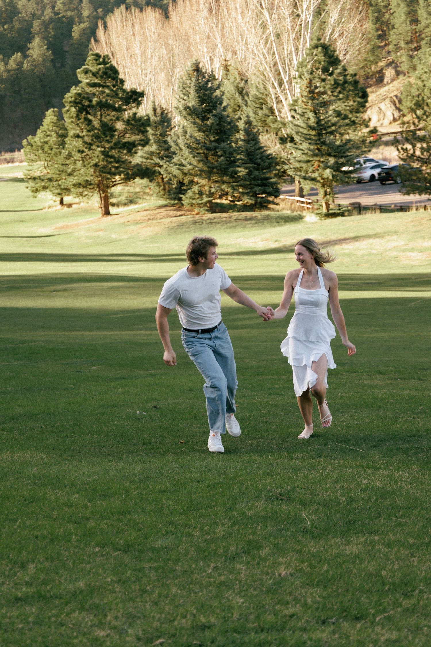 Evergreen Colorado engagement, frolecking through a meadow at golden hour