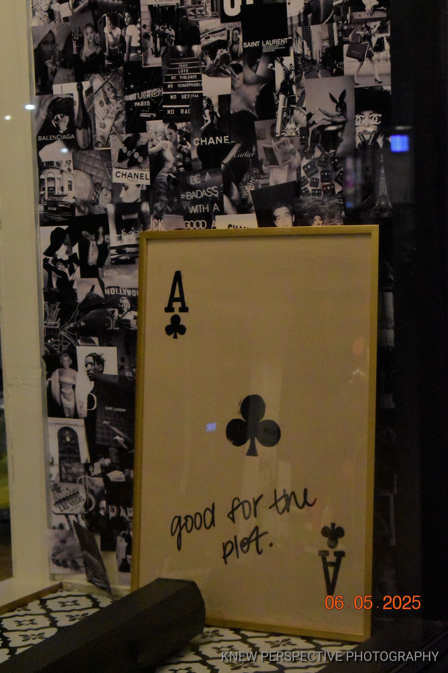 Black and white collage wall with yellow framed artworks displaying handwritten text in a gallery setting.