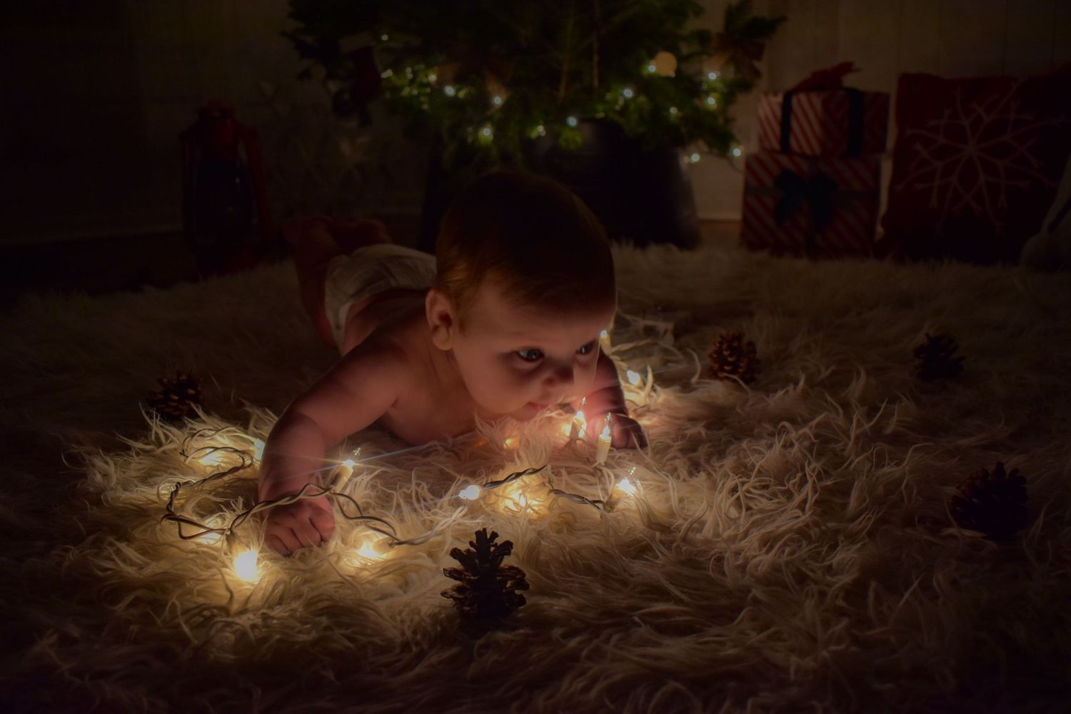 A string of glowing fairy lights creates a warm, magical ambiance in a dark room with pine cones and natural decor.