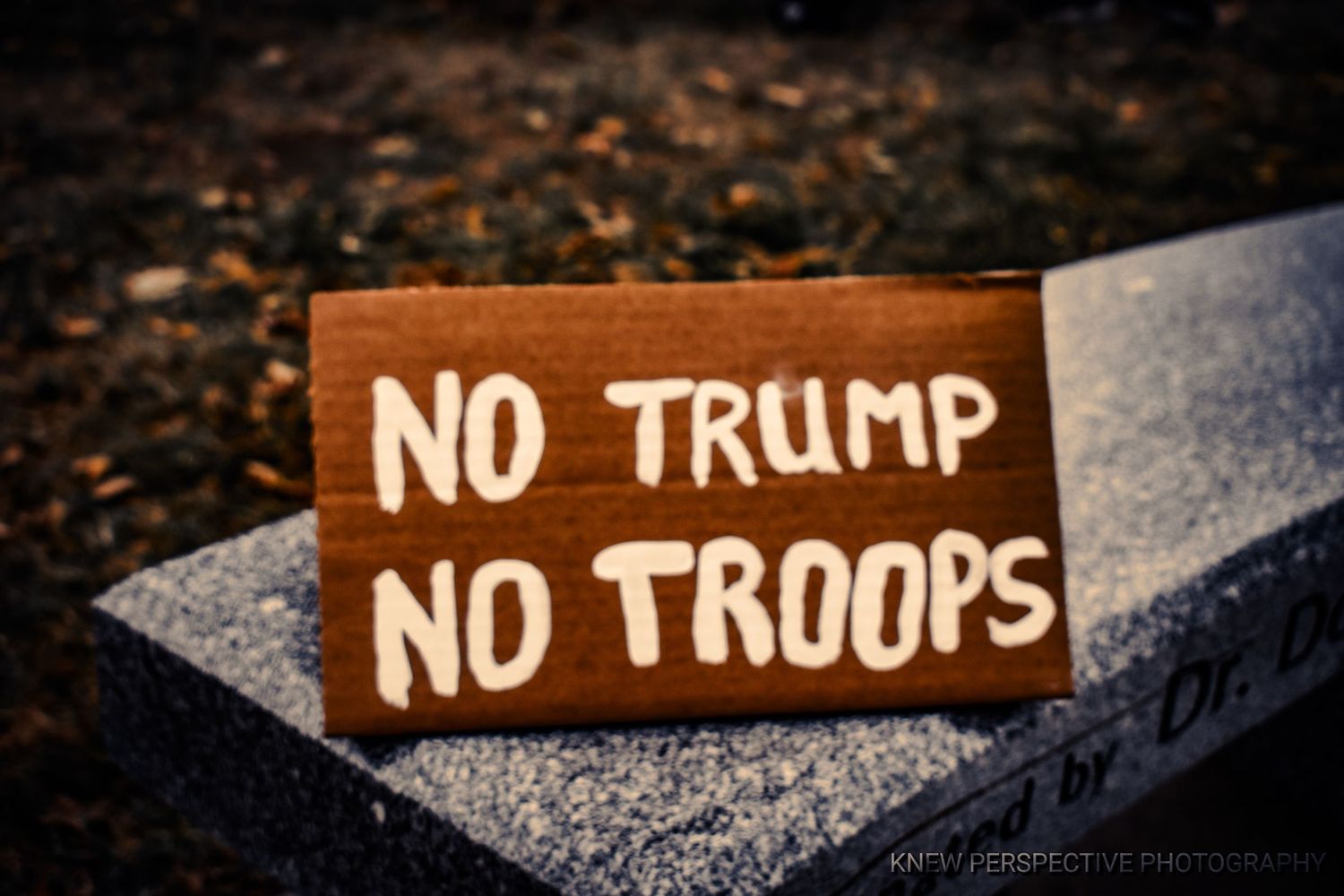 A modest cardboard protest sign with the text 