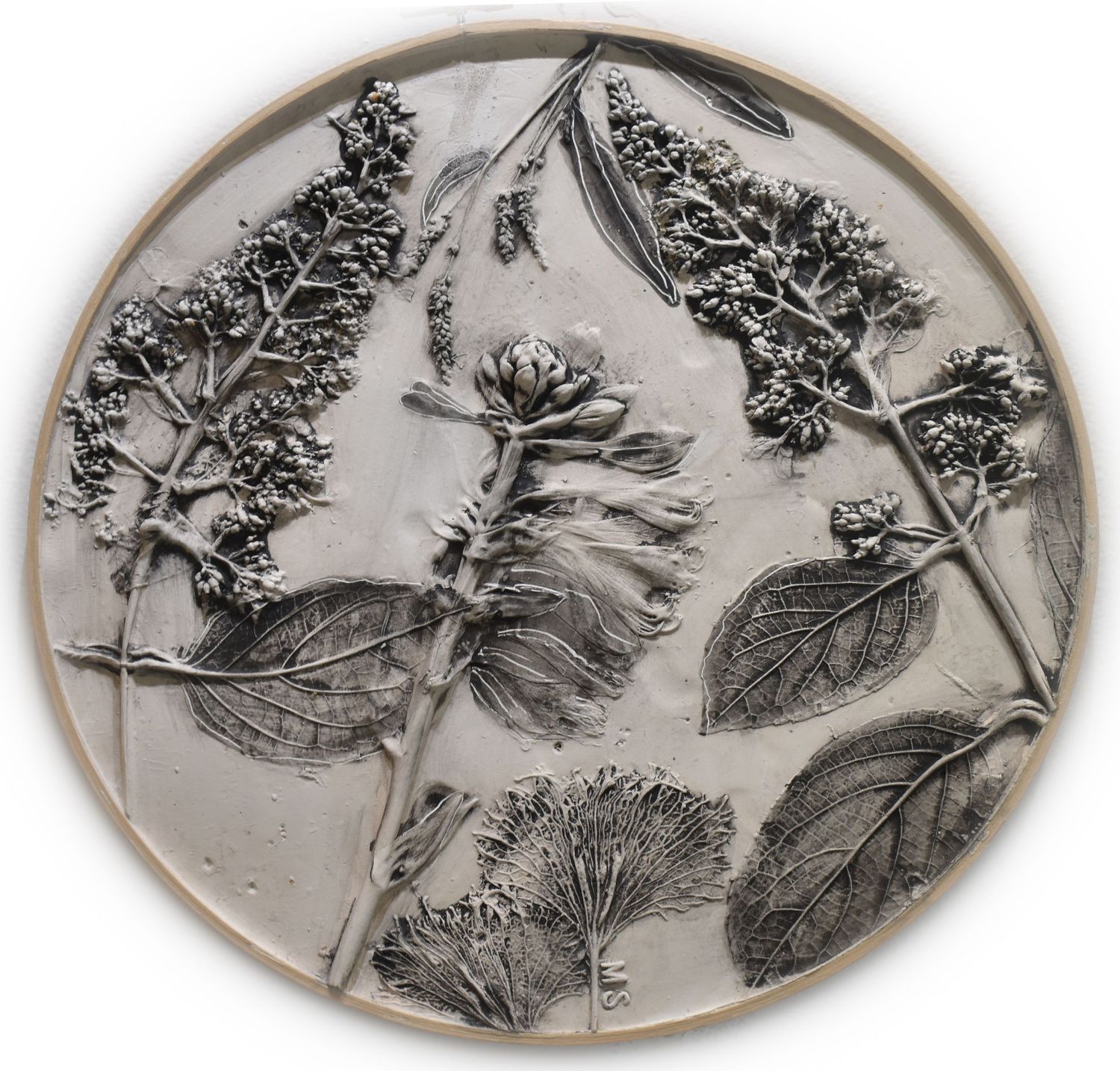 Black and white botanical illustration showing delicate floral patterns with leaves and blooms in oval frames.