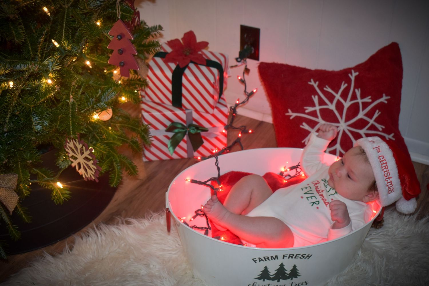 A Christmas scene with a decorated tree and red lighting creating a festive holiday ambiance.