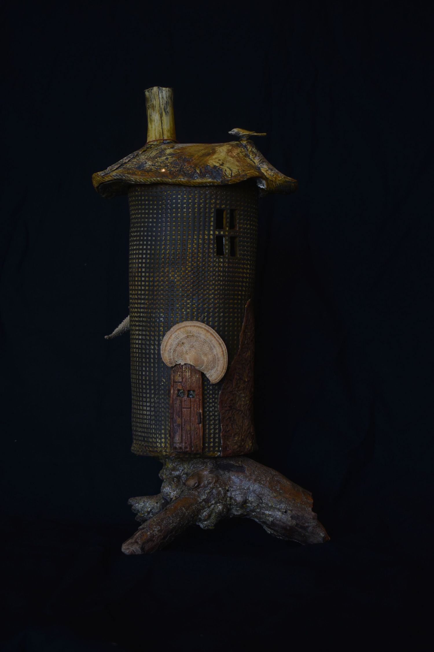 A mixed media Clay sculpture photographed against a dark background.