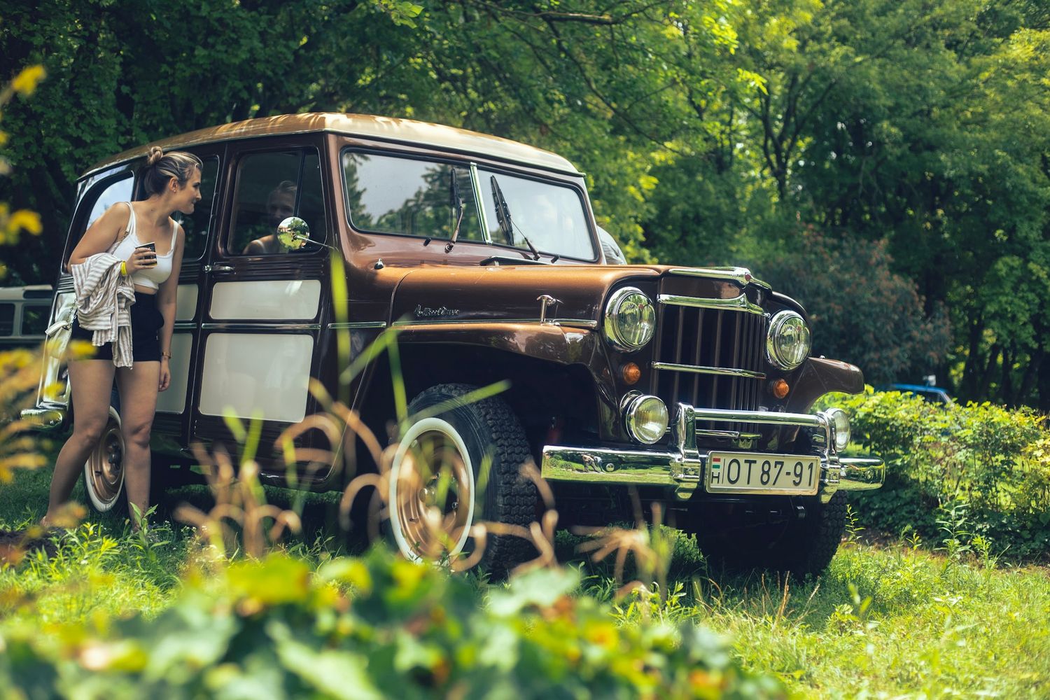 Egy nő csodálja az old timer autót.