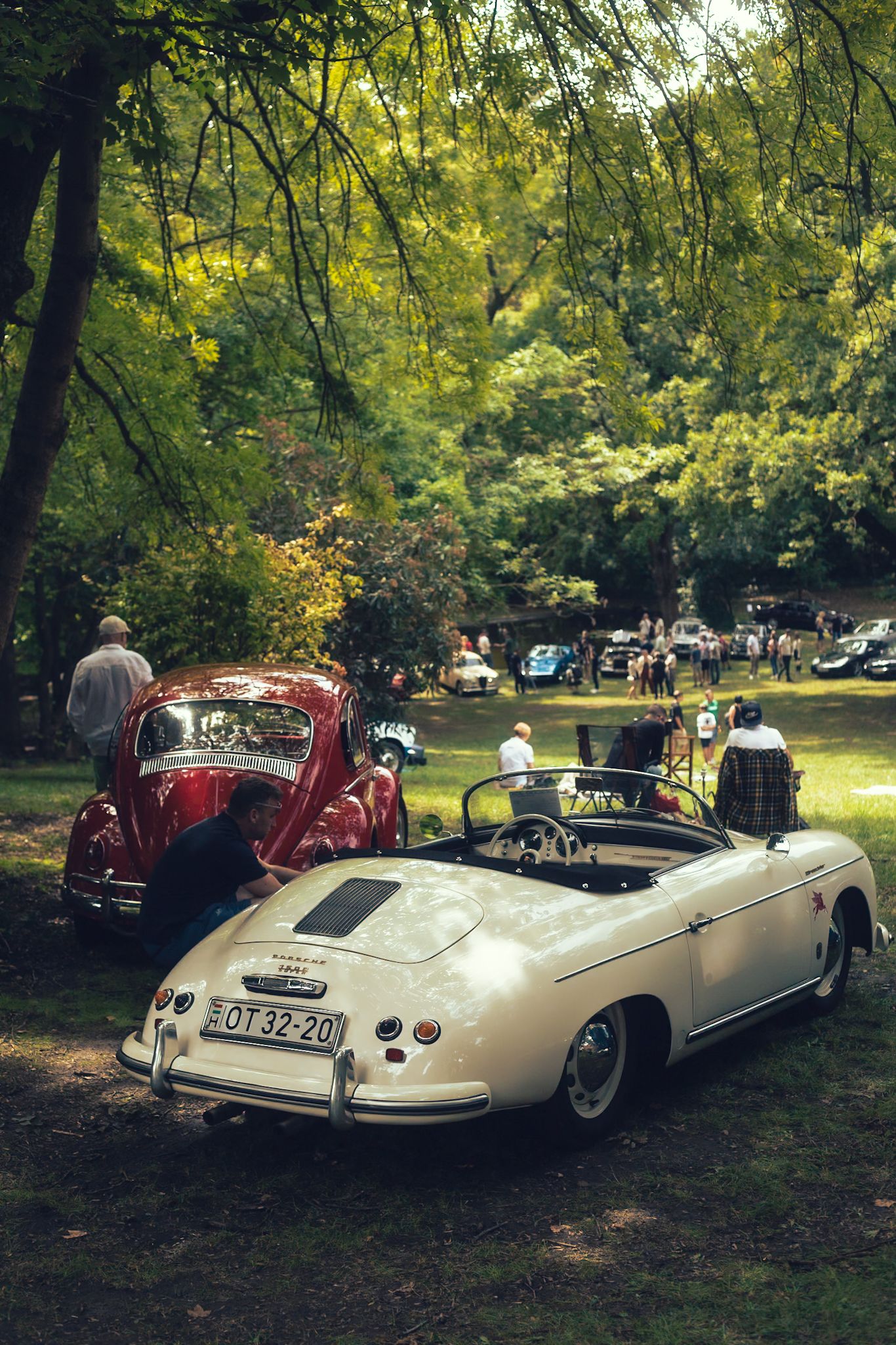 Autós piknik hangulatos nyüzsgése, előtérben old timer autókkal. Autós rendezvényfotózás Budapest környékén.