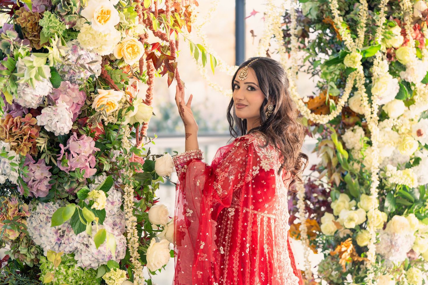 Romantic floral arch with pink and white blooms creating an elegant garden setting.
