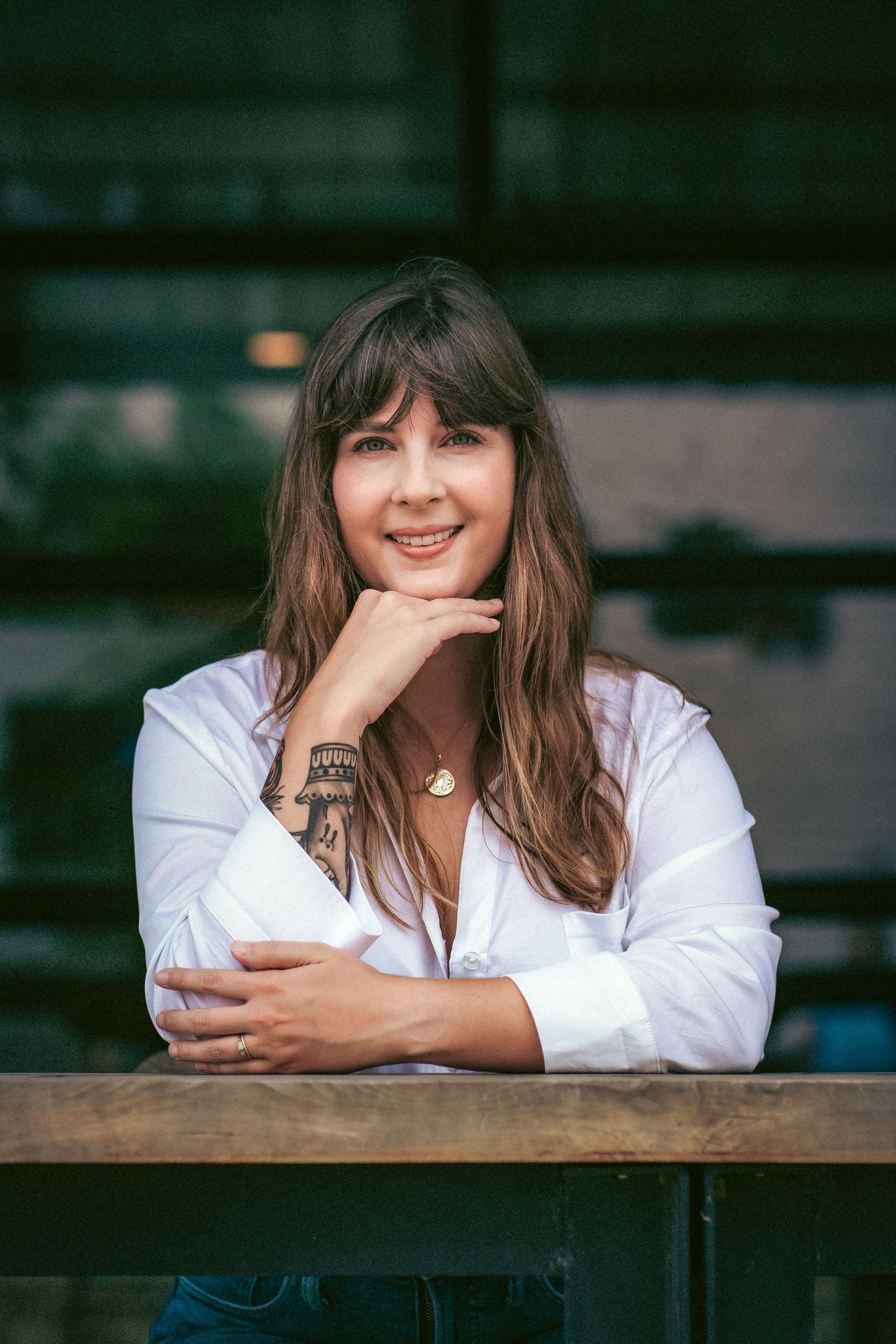 Professional headshot series showing a warm smile and relaxed poses against a dark background.