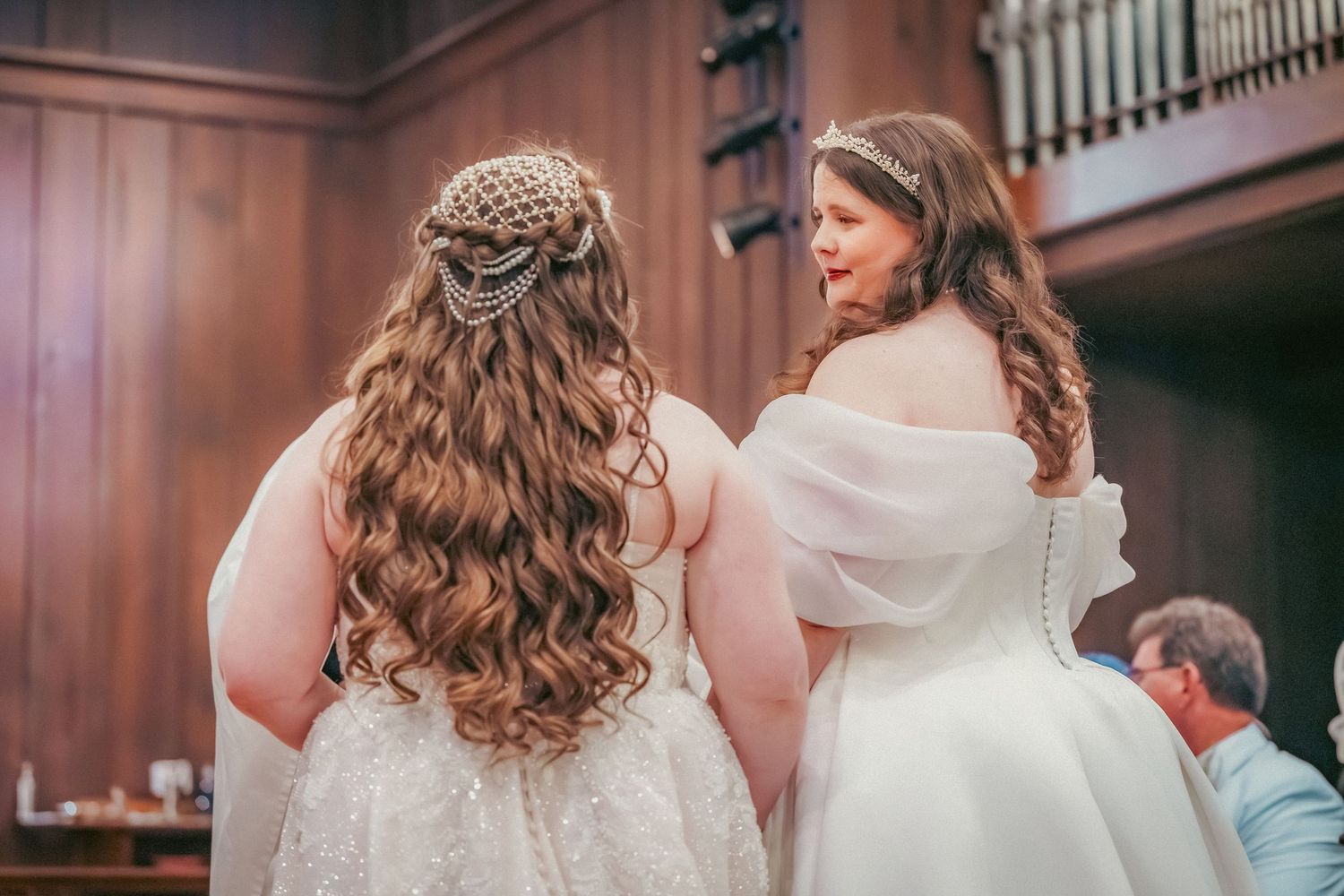 Wedding ceremony taking place in an elegant church with wooden architectural details.