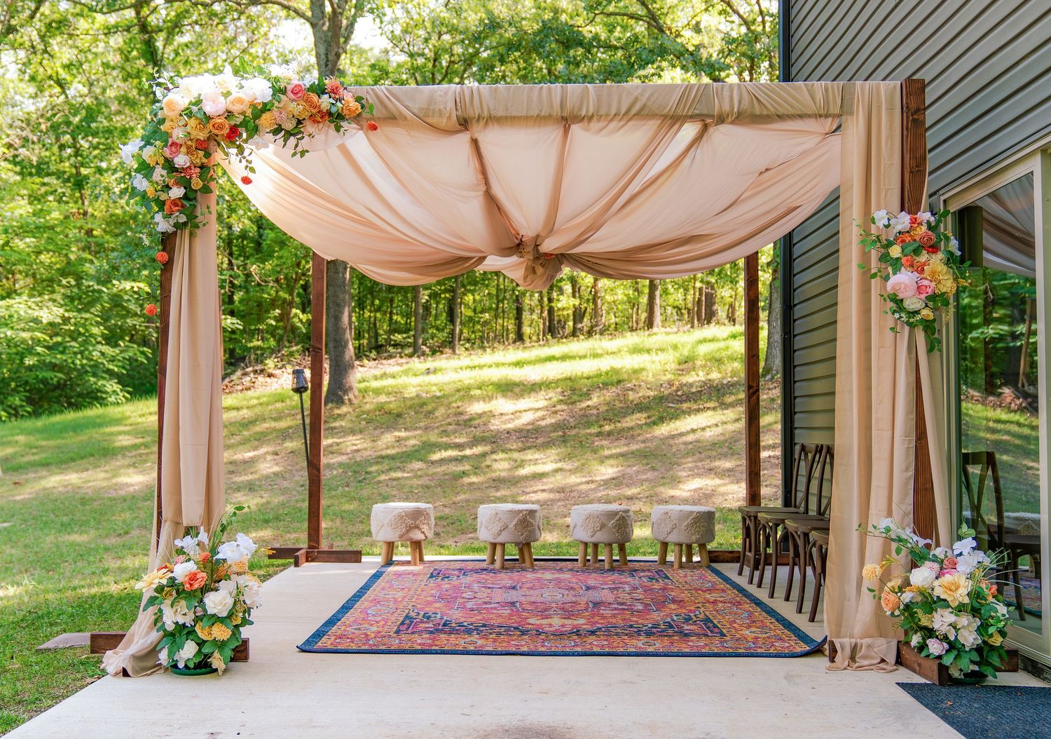 An outdoor wedding venue with draped fabric canopy and elegant seating arrangement.