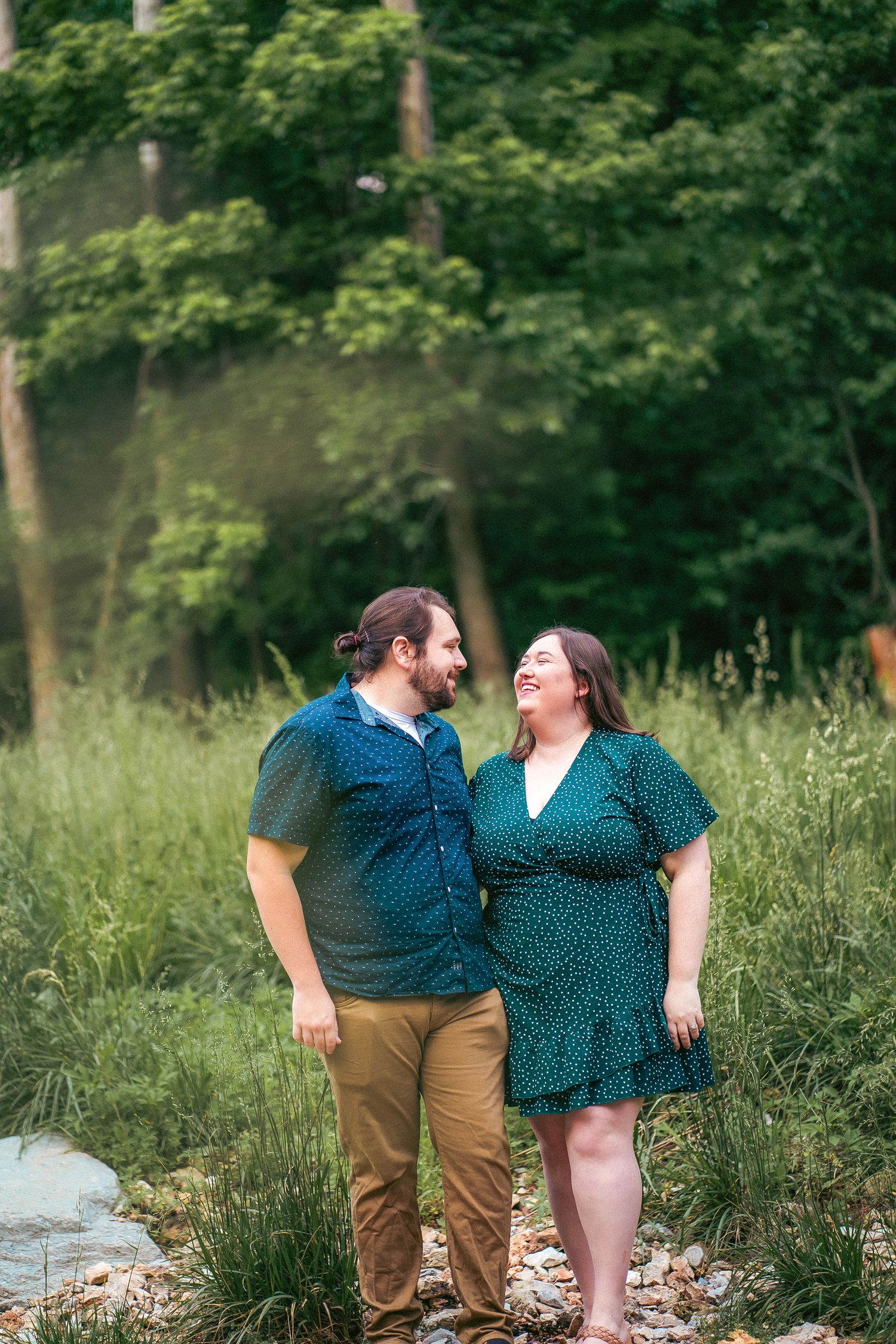 A couple in polka dot outfits shares laughs during their outdoor photography session.