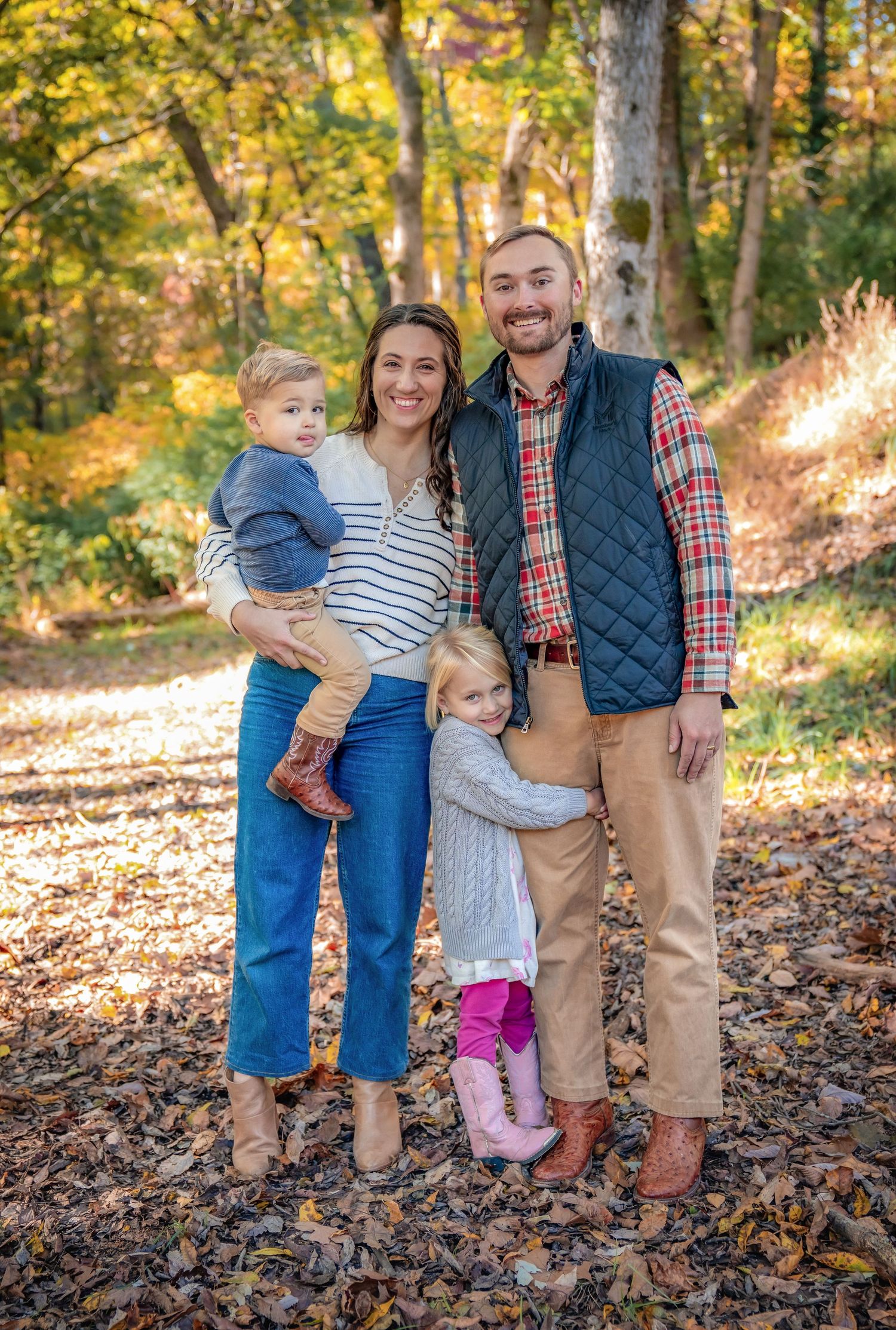 Group portrait on fallen leaves with autumn foliage in background.