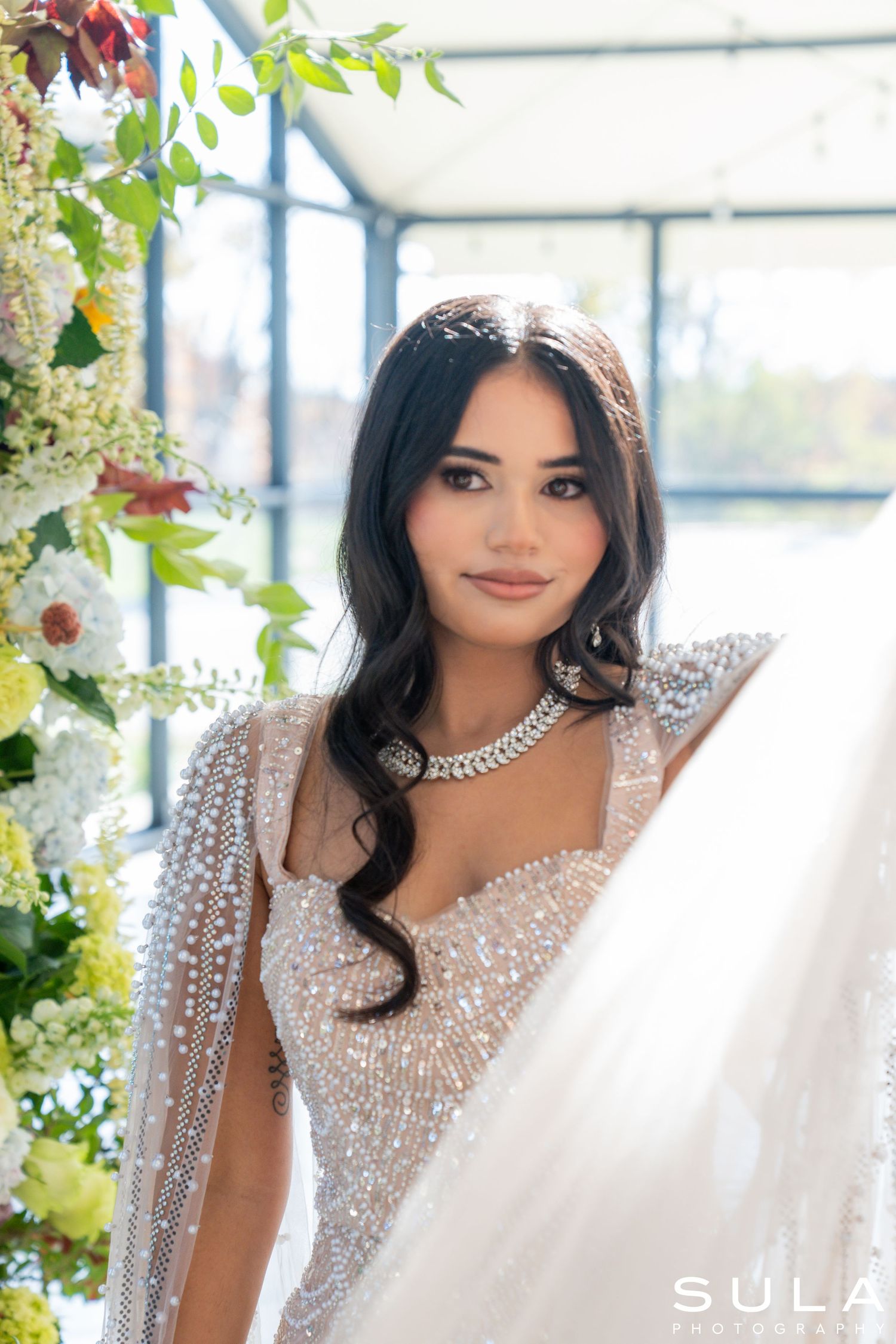 Glamorous bridal portraits in a sunlit greenhouse with sparkling beaded gown.