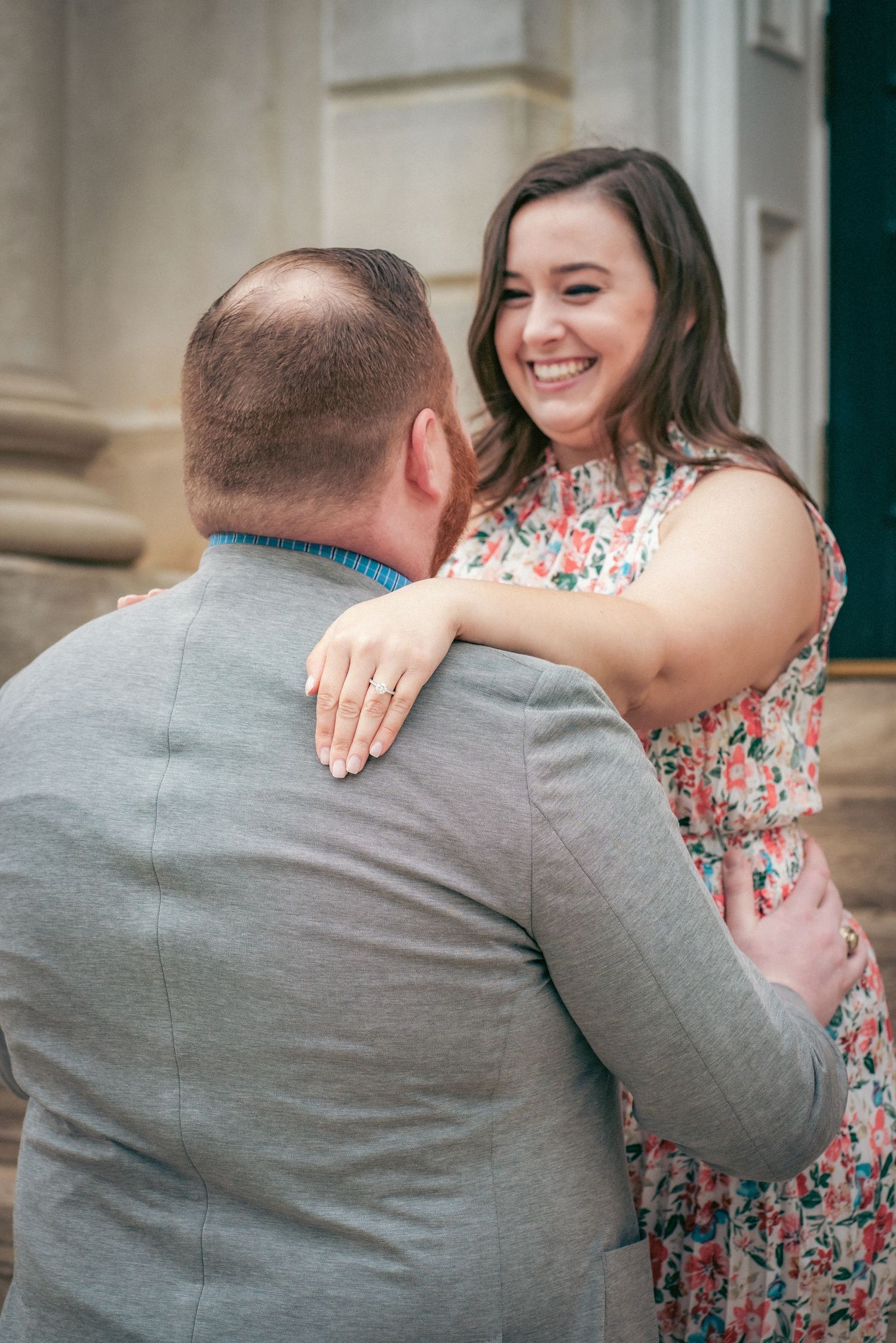 Emotional engagement moment captured on stone steps of historic building.