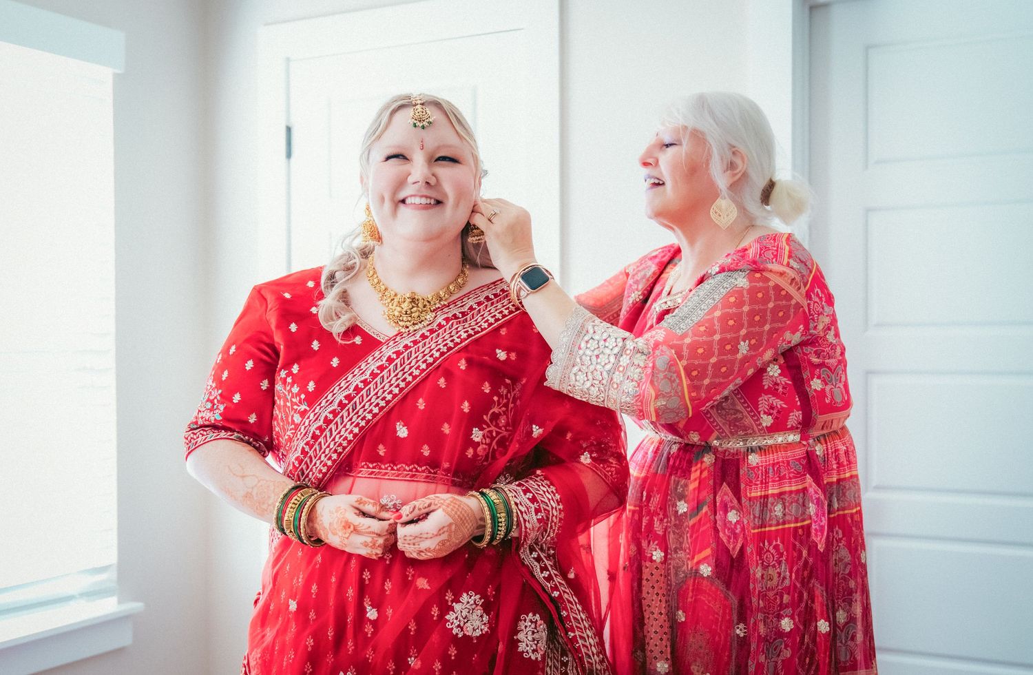 Multiple mirror reflections of traditional red formal wear with intricate embellishments.
