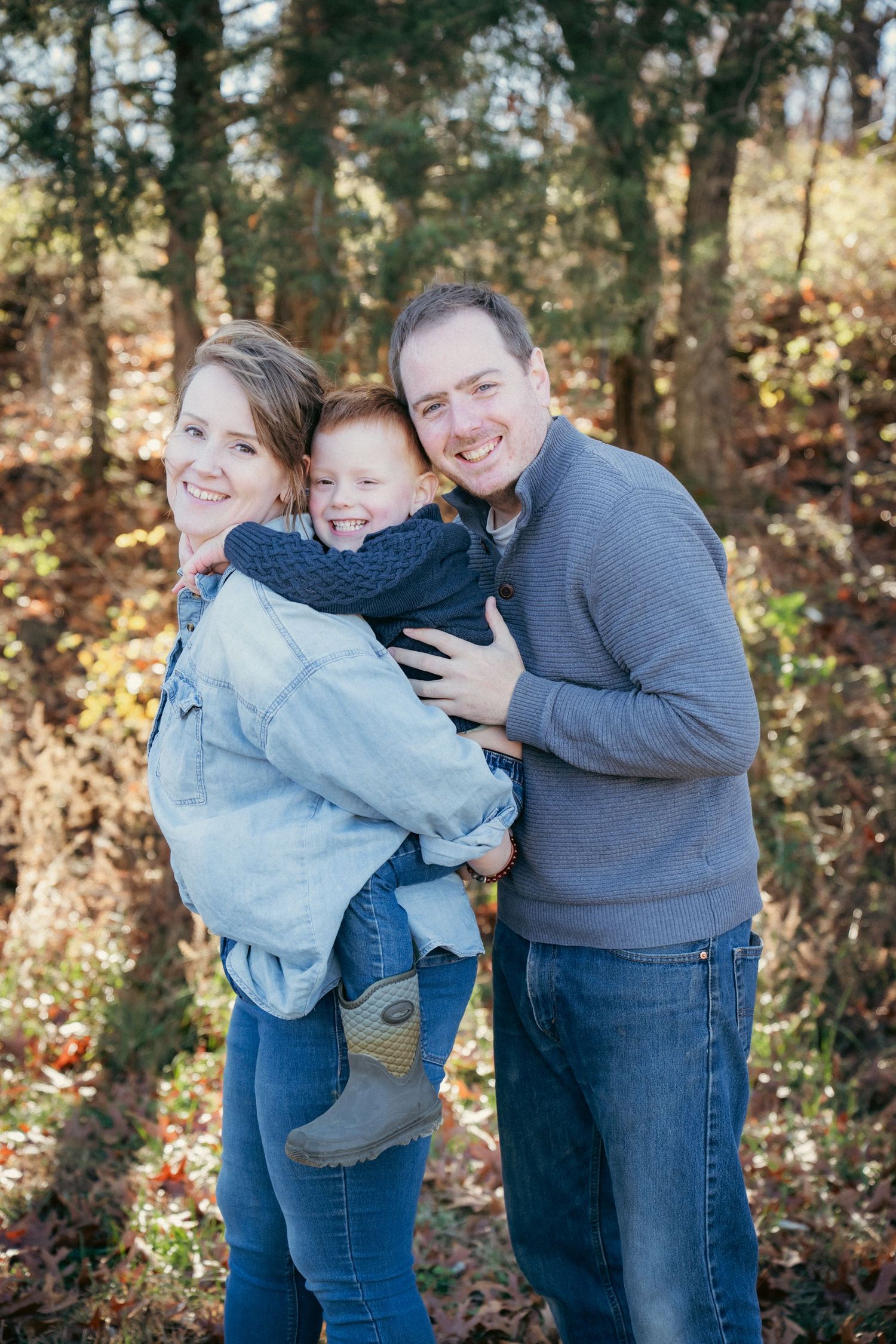 Playful family interaction sequence captured in wooded autumn setting.