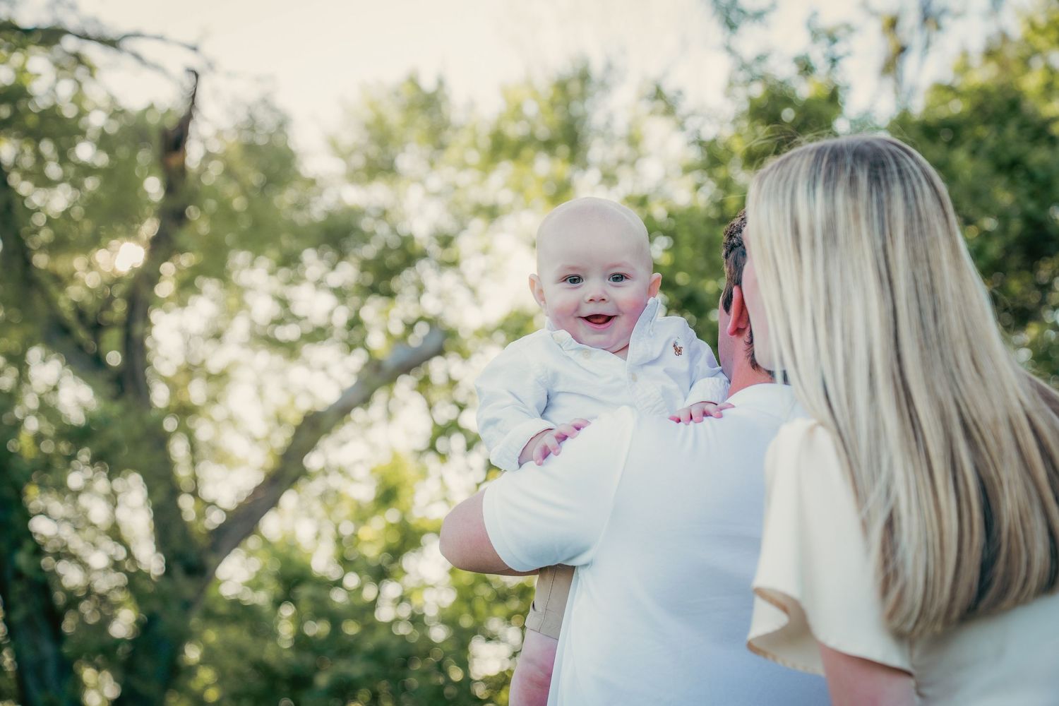 Intimate family moment captured on blanket during outdoor photo session.