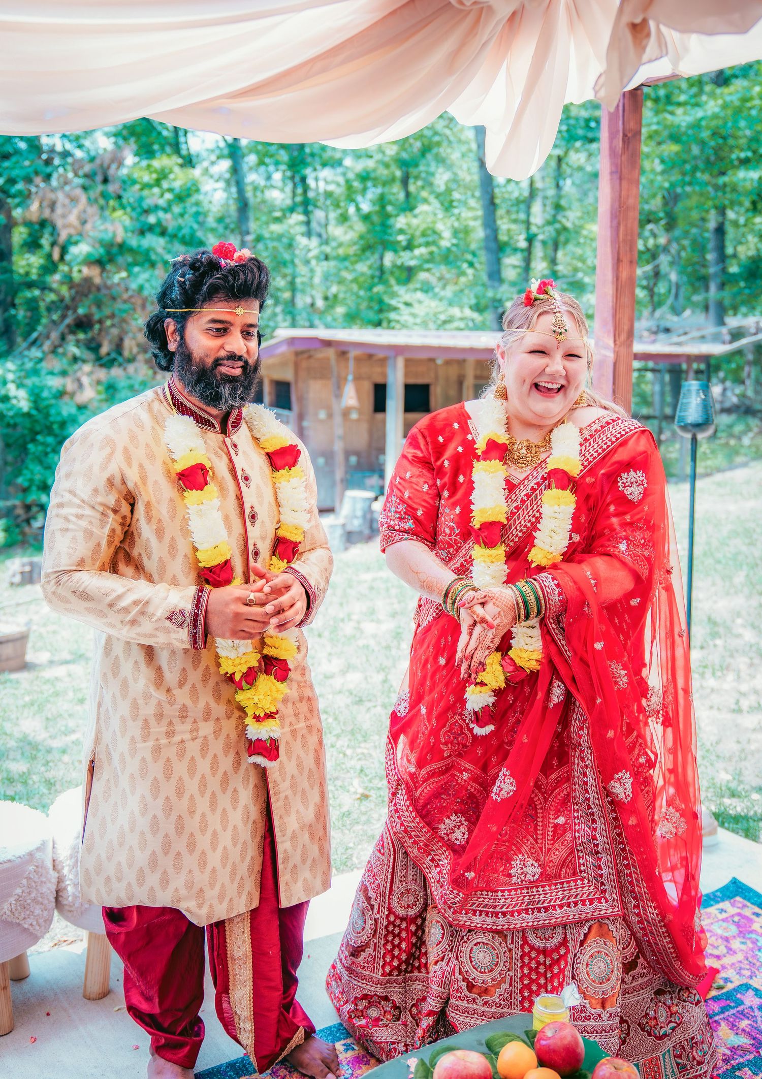 Joyful moments during an Indian wedding ceremony with traditional garlands and customs.