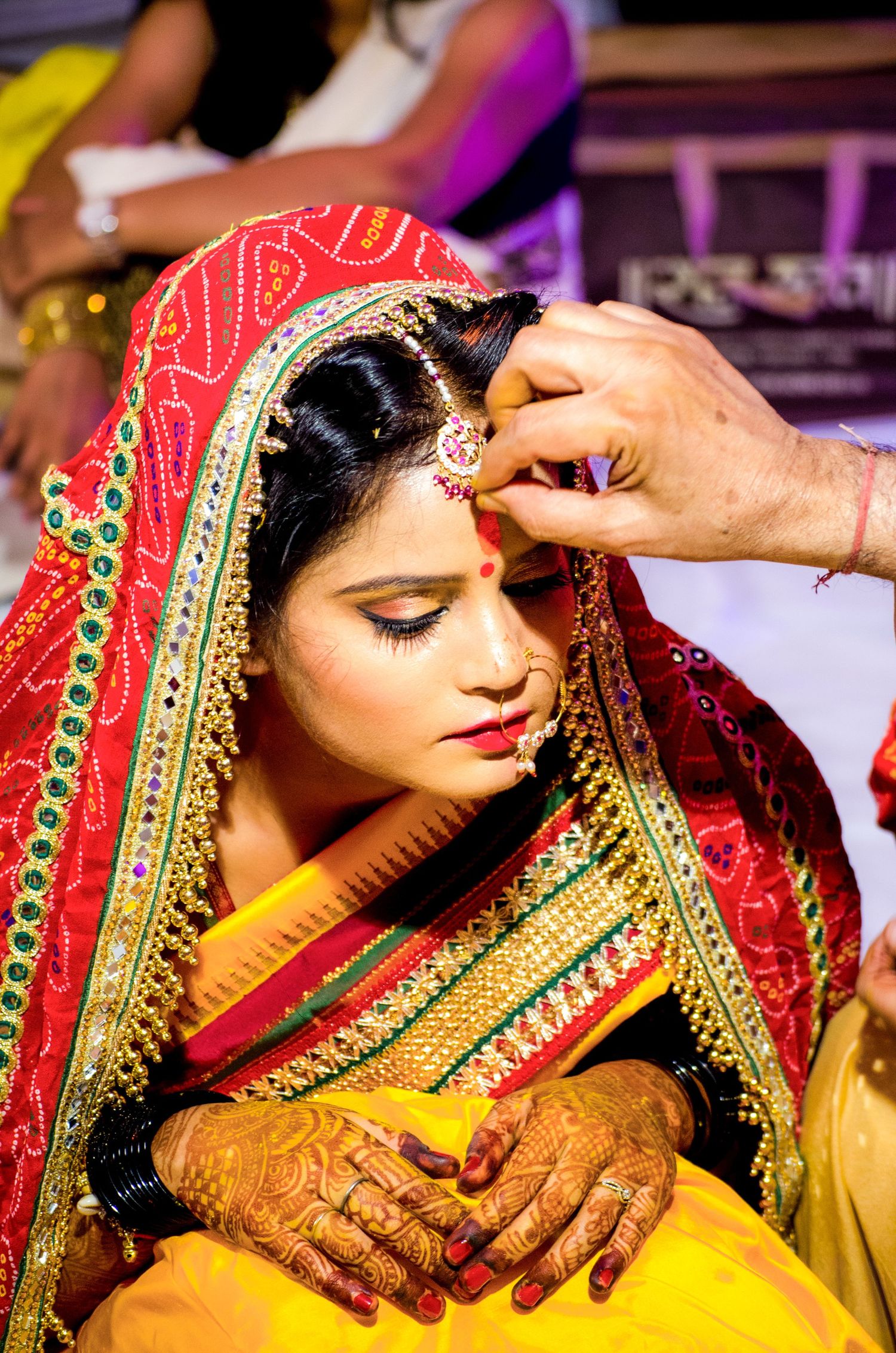 Close-up of intricate henna designs and bridal jewelry during Indian wedding preparations.