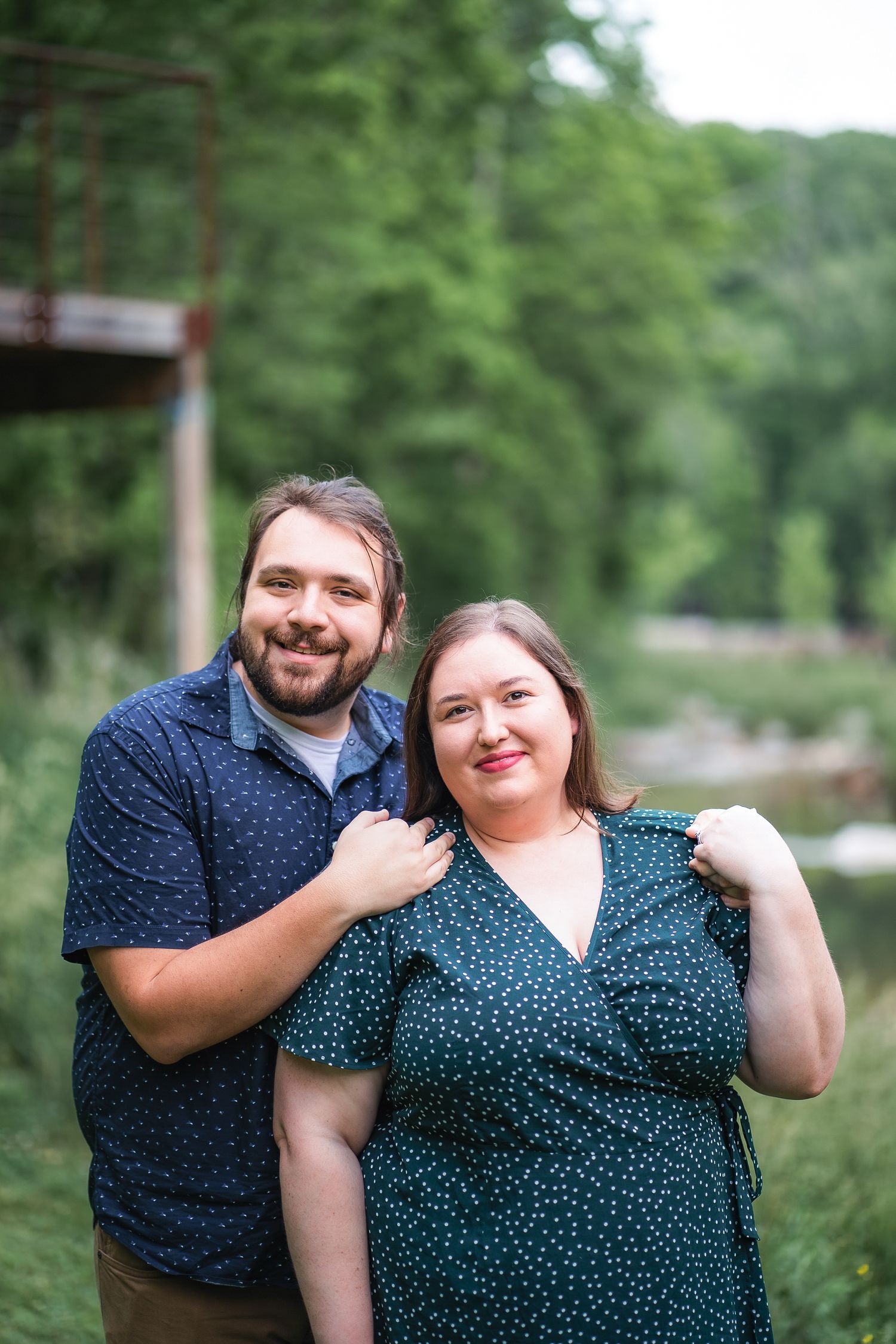 A couple in coordinated blue outfits shares joyful moments during their outdoor photoshoot.