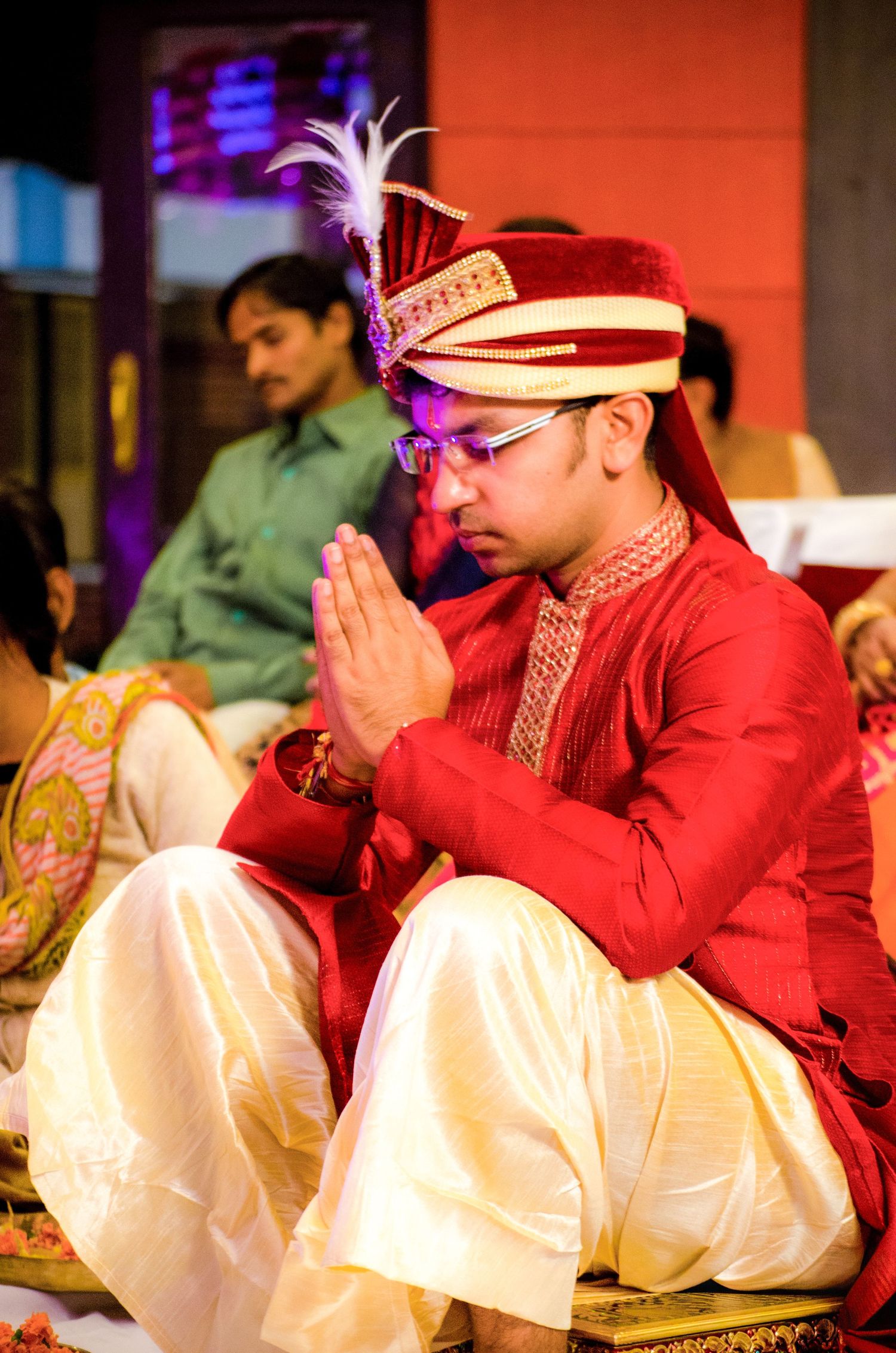 Wedding ceremony participants seated in traditional Indian attire during religious rituals.