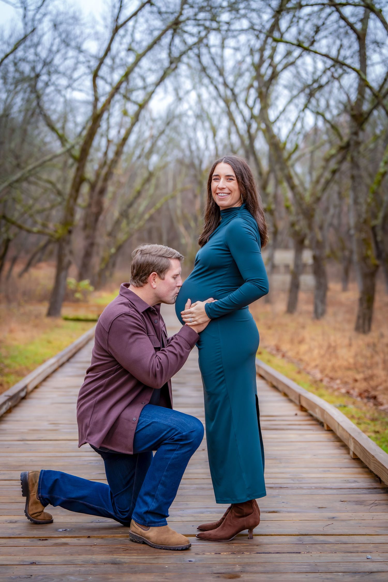 Sweet moments captured on a wooden boardwalk during a maternity photoshoot.