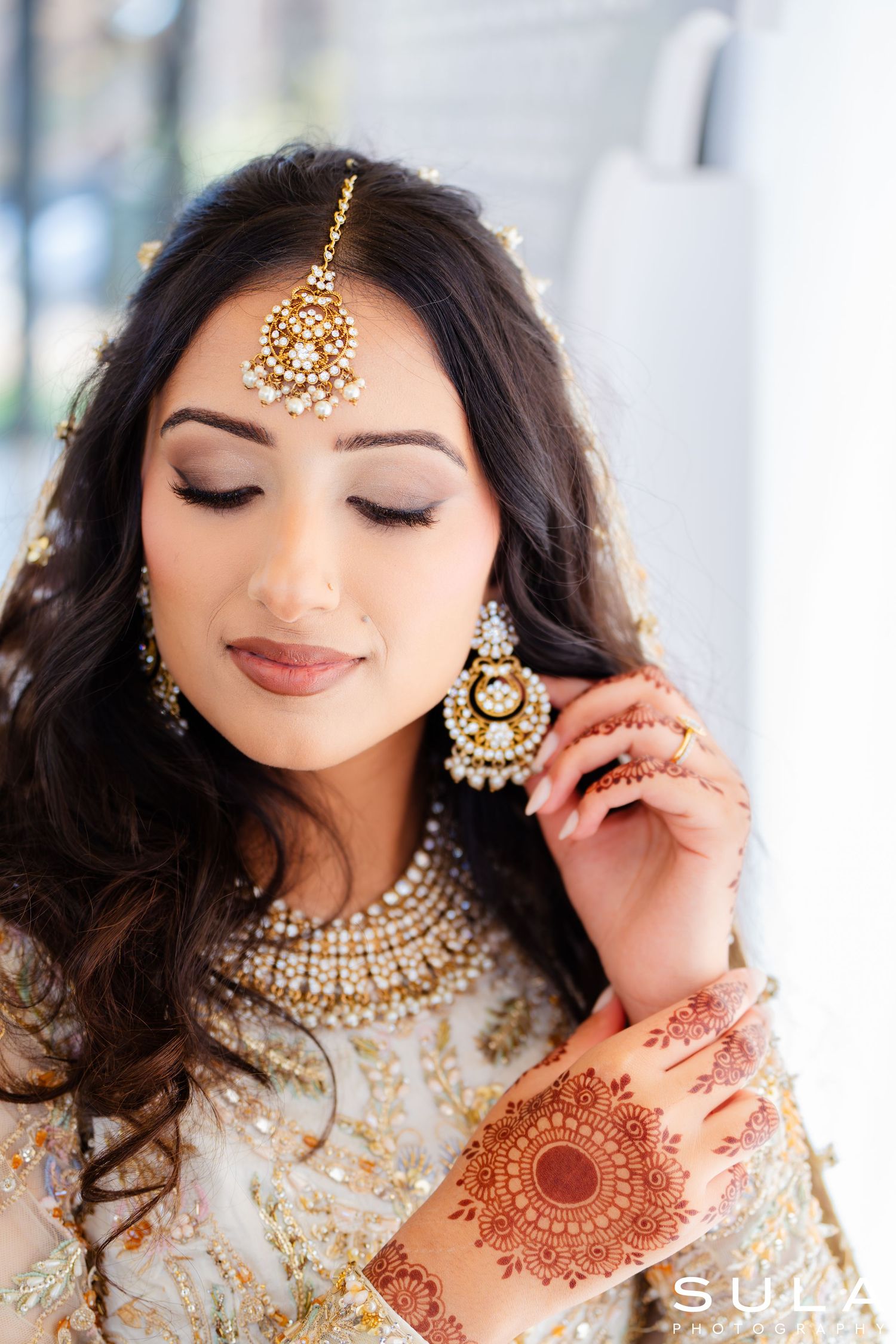 South Asian bridal beauty shots featuring gold jewelry, henna designs and elegant makeup.