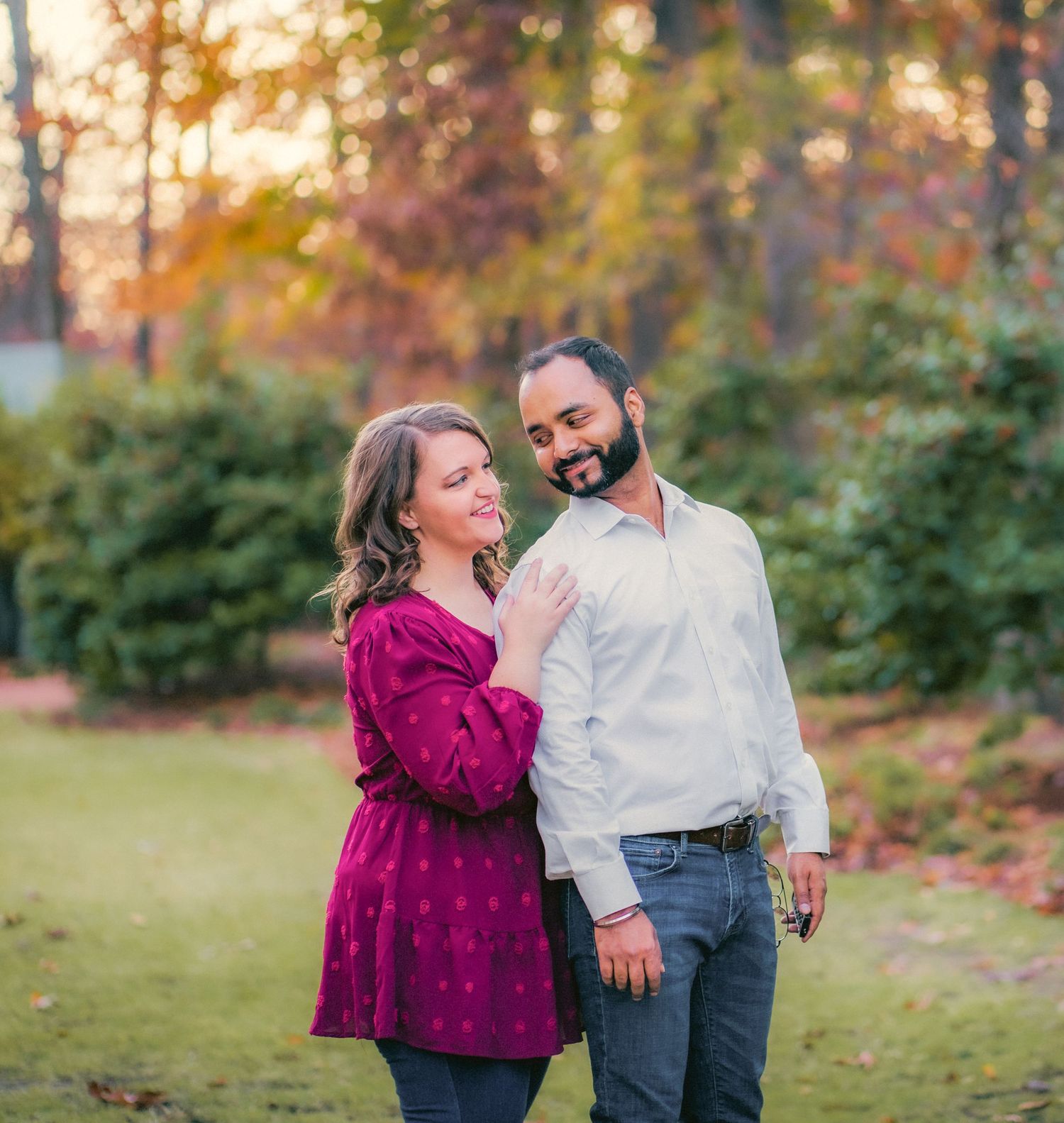 Couple sharing a joyful moment in an autumn park at sunset.