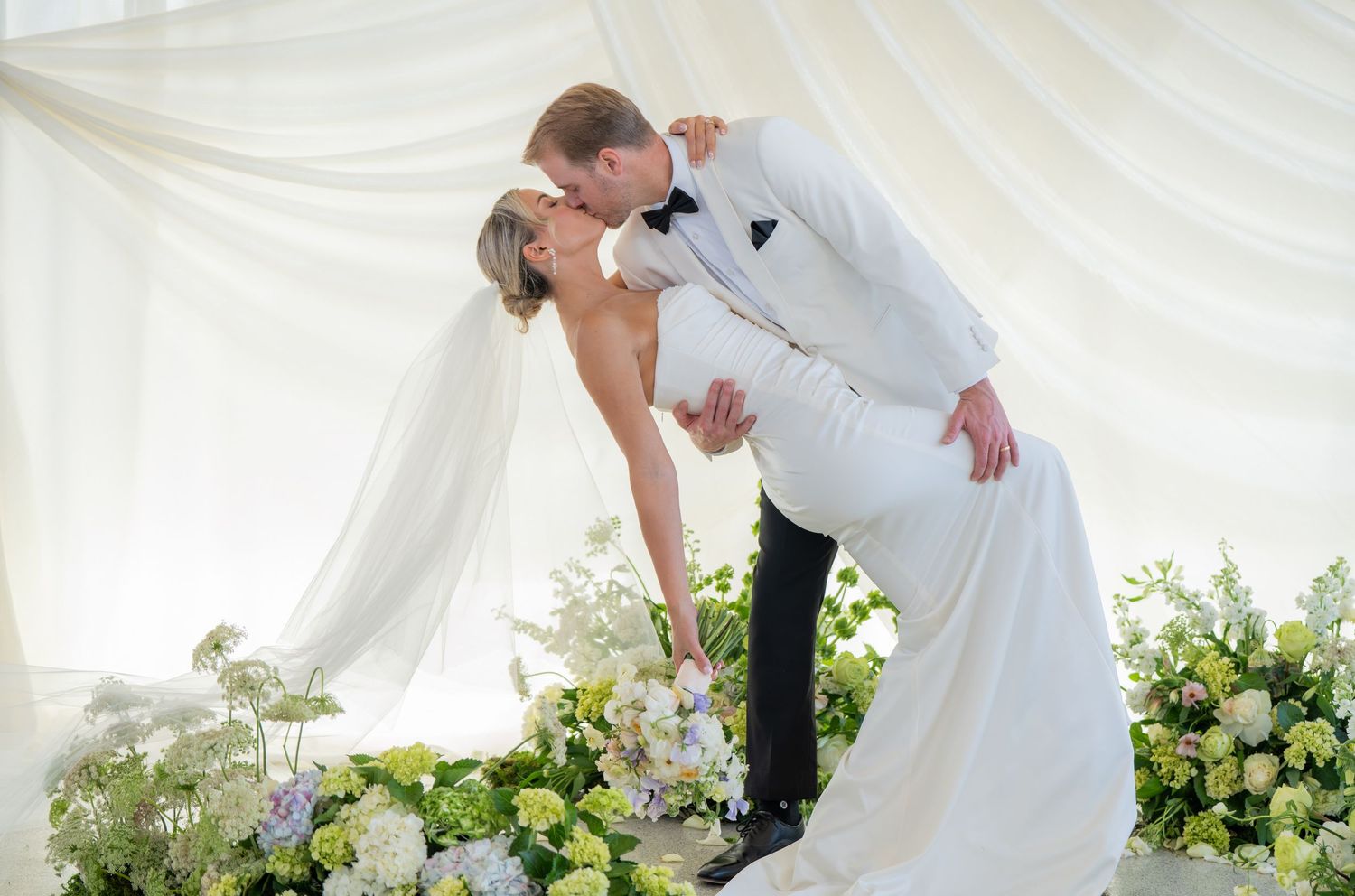Romantic wedding photos captured in sequence under an elegant white tent with greenery.