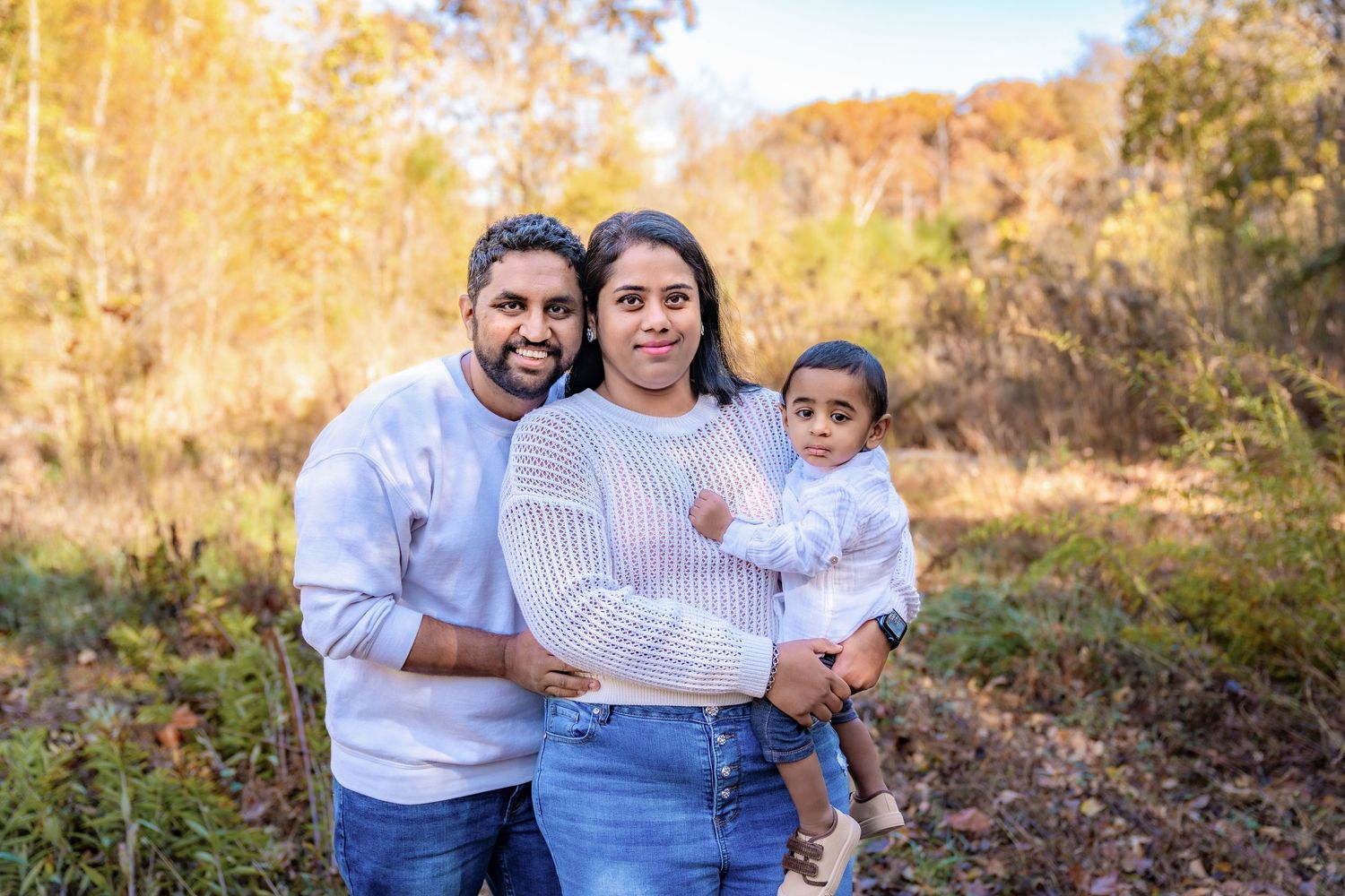 Family outdoor portrait session in warm autumn sunlight.