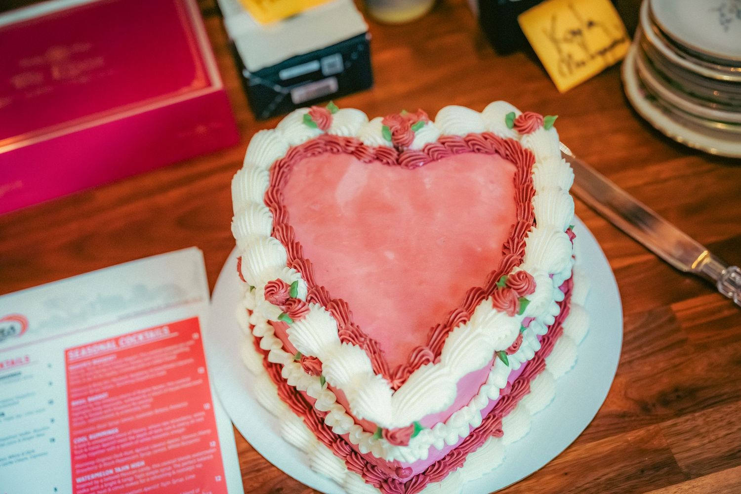 Heart-shaped pink desserts displayed on white plates at a wedding reception.