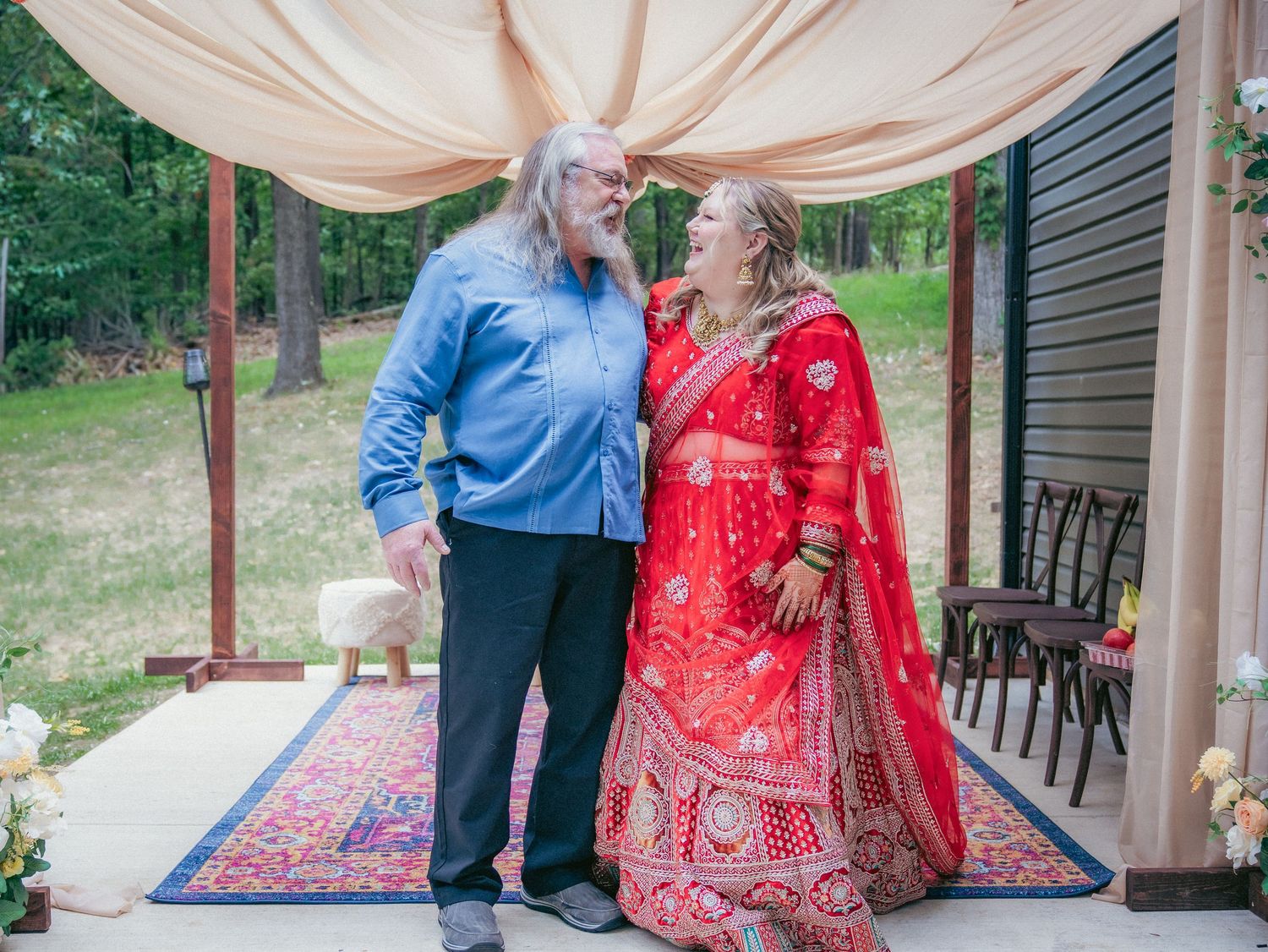 Wedding guests gather under a decorated outdoor canopy for traditional Indian ceremony celebrations.