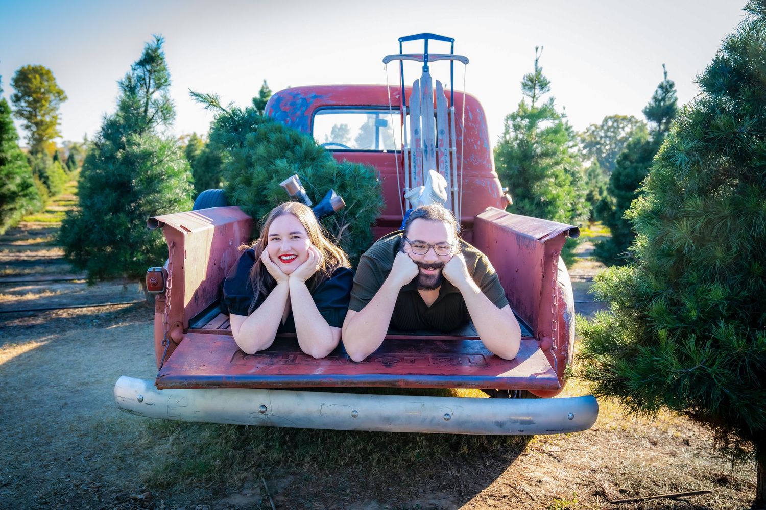 Playful photo sequence in an old red pickup truck at a Christmas tree farm.