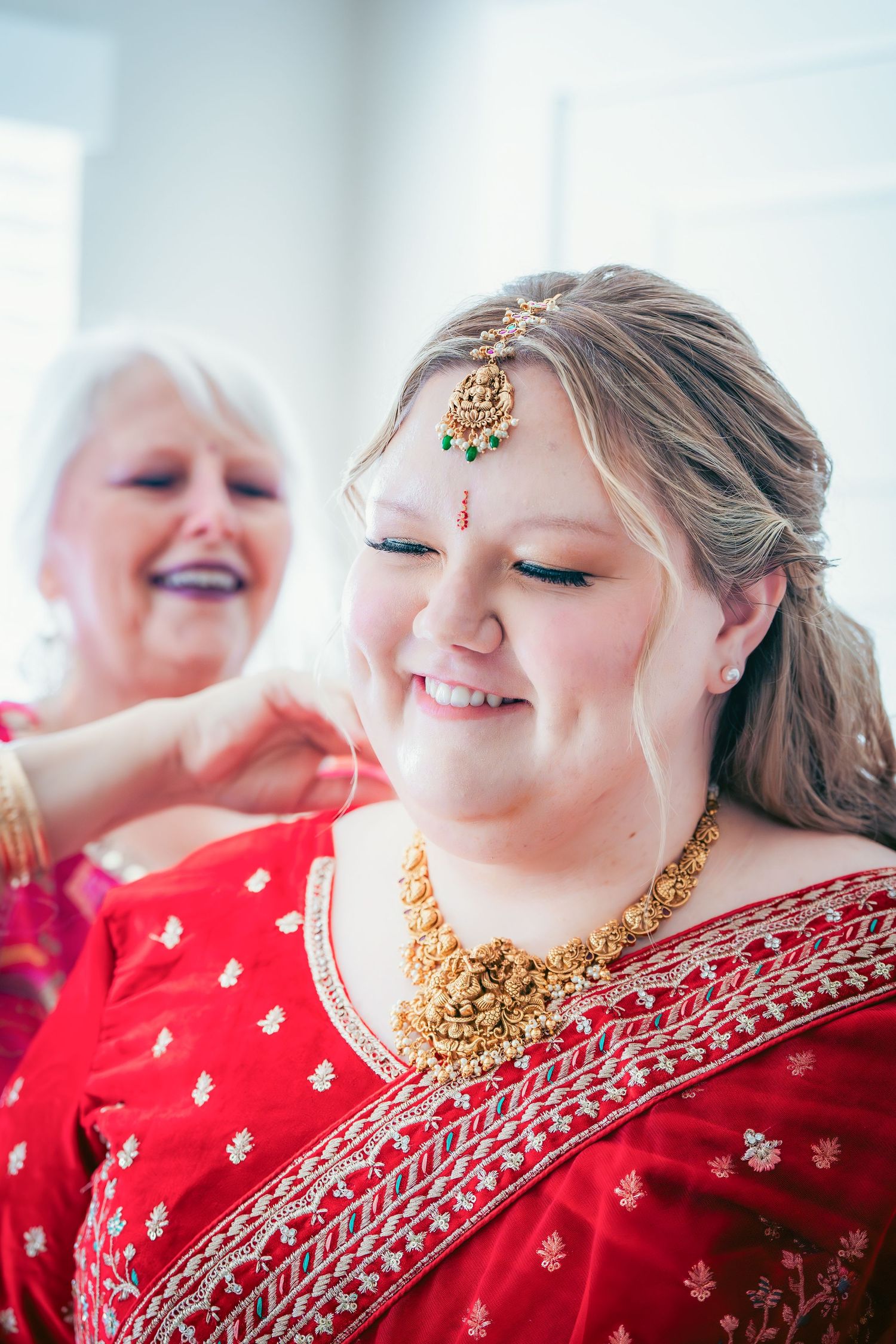 Person wearing traditional red Indian wedding attire and gold jewelry smiling in a candid photo series.