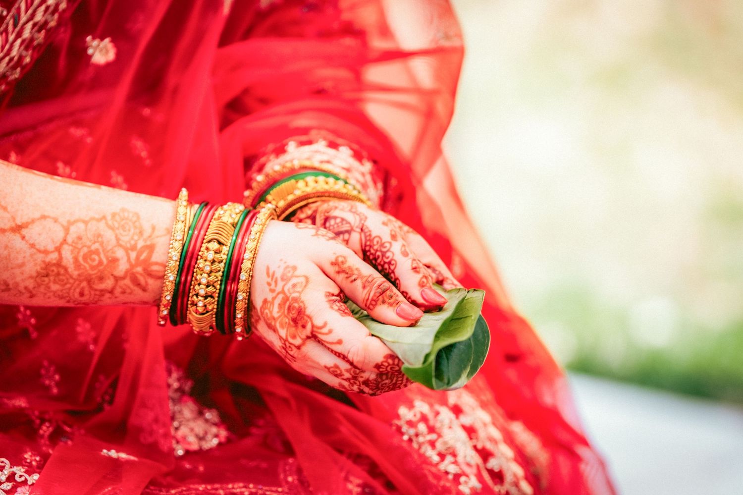 Detail shots of traditional Indian bridal jewelry and henna decorated hands.