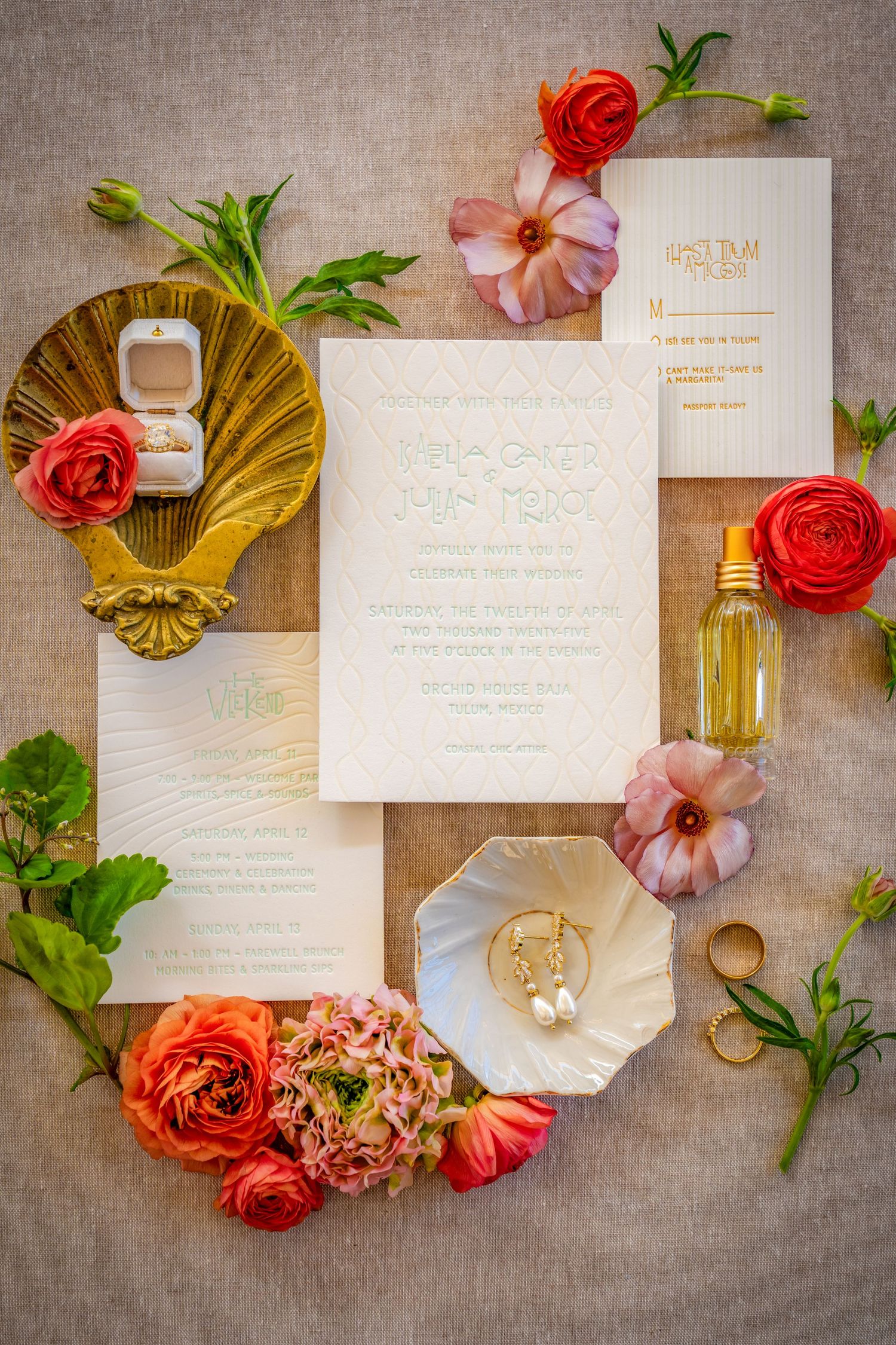 Wedding invitation suite styled with coral roses and gold shell decorative elements.