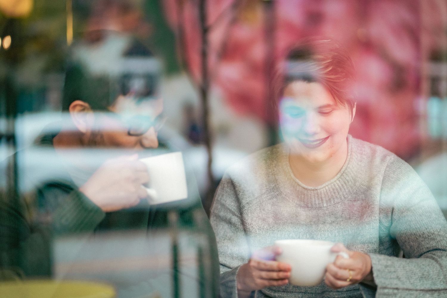 People sharing warm drinks and conversation at a cozy cafe table.