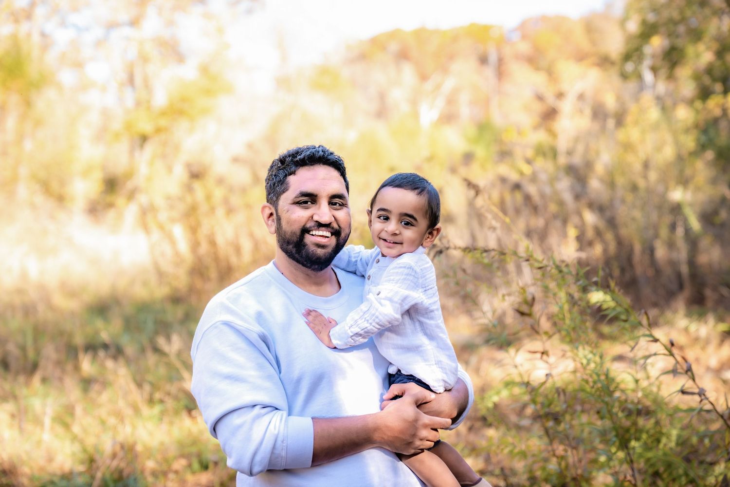 Joyful outdoor portrait session in golden autumn lighting.