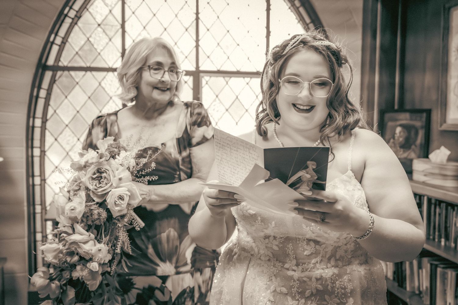 Wedding celebration captured through arched window with elegant decor and lighting.