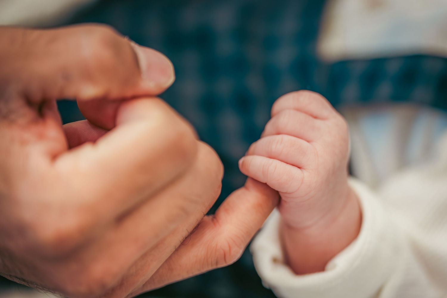 Gentle close up of baby's tiny hand being held.