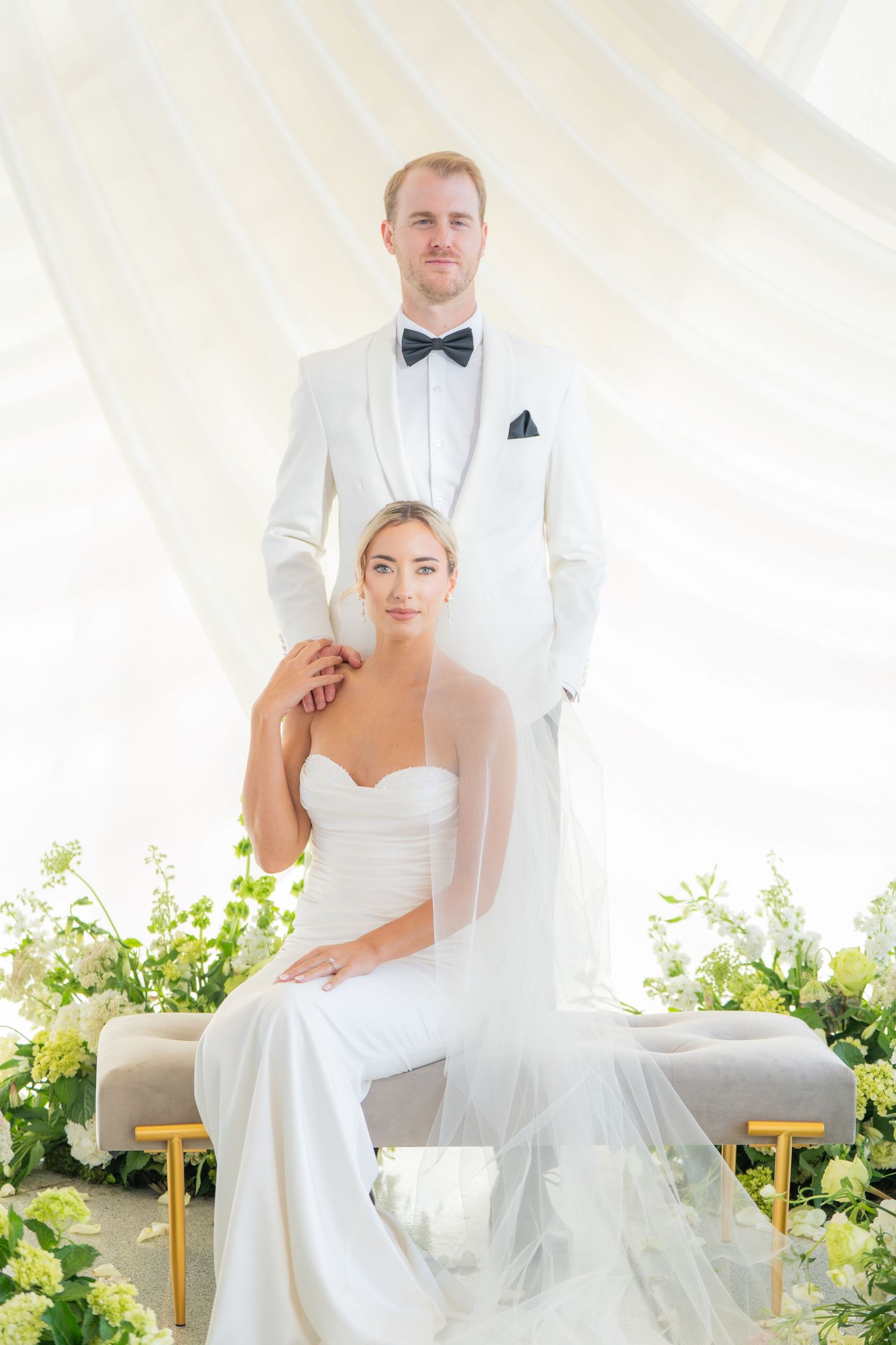 Modern wedding portraits with couple in white tuxedo and strapless gown outdoors.