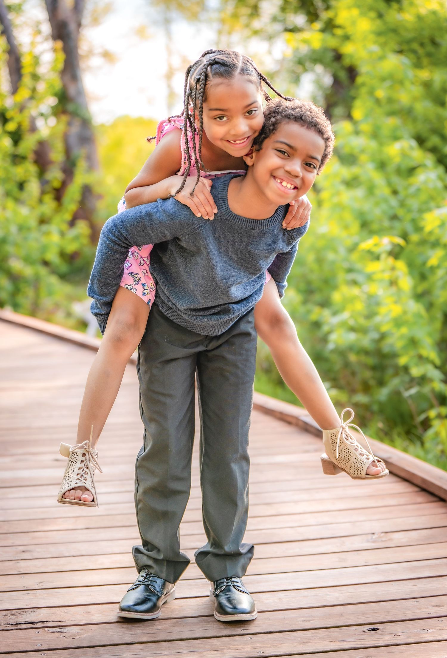 Playful sibling interactions captured on a wooden deck during a photo session.