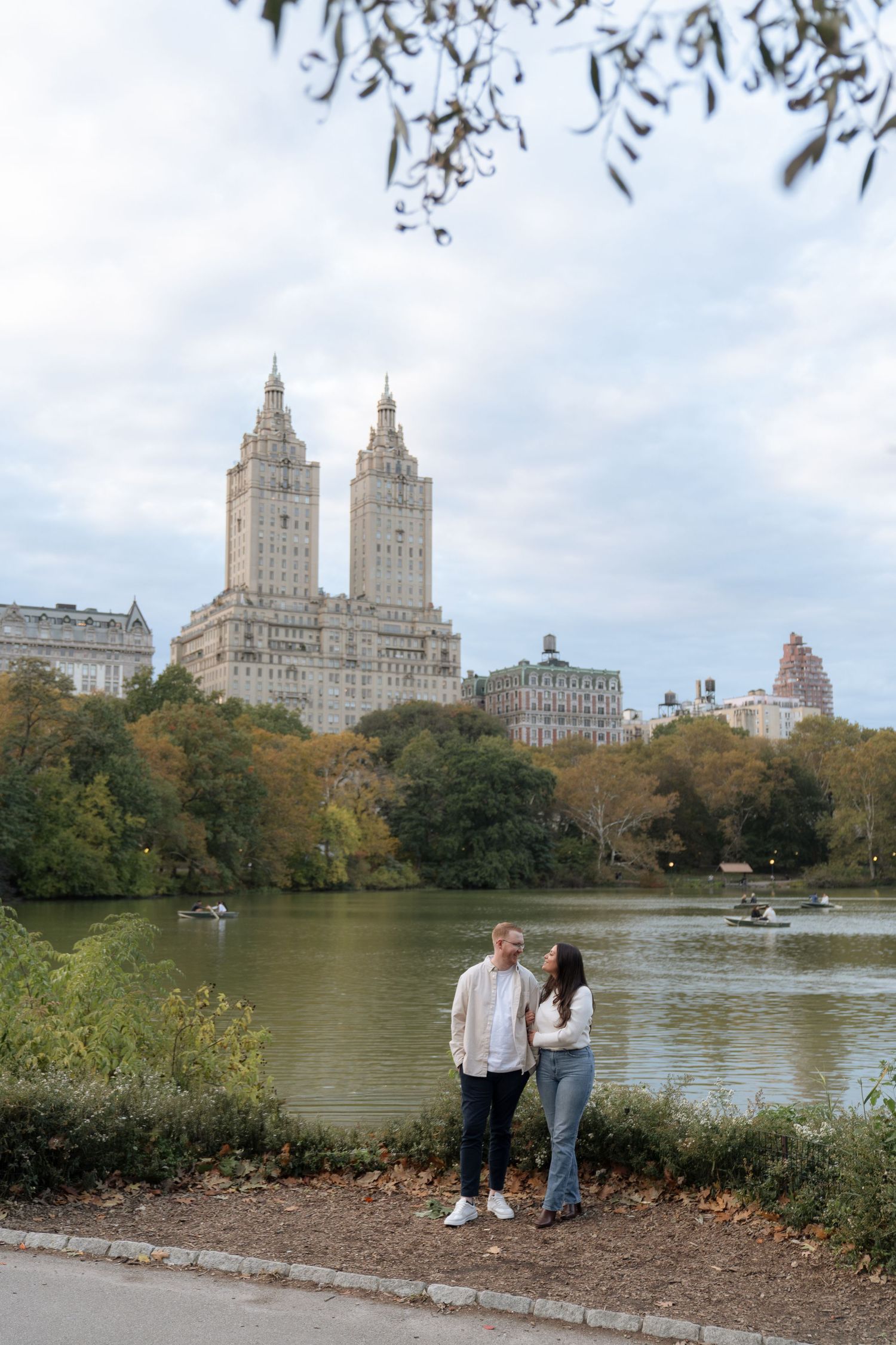 Scenic view of Central Park lake with iconic NYC buildings in the background.