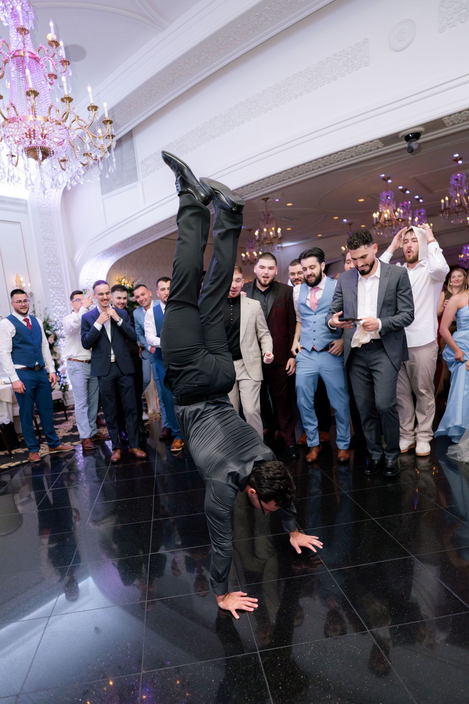 Guest performs an impressive handstand on the dance floor during wedding celebrations.