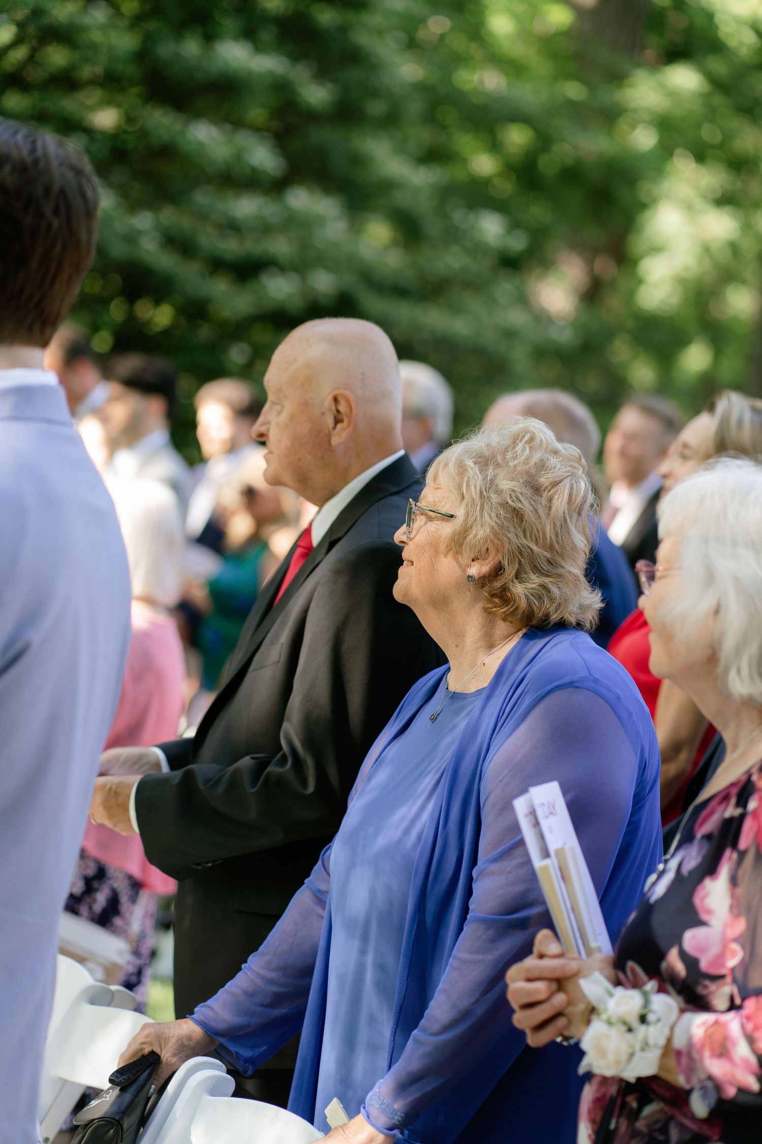 Wedding guests seated outdoors watching the ceremony.